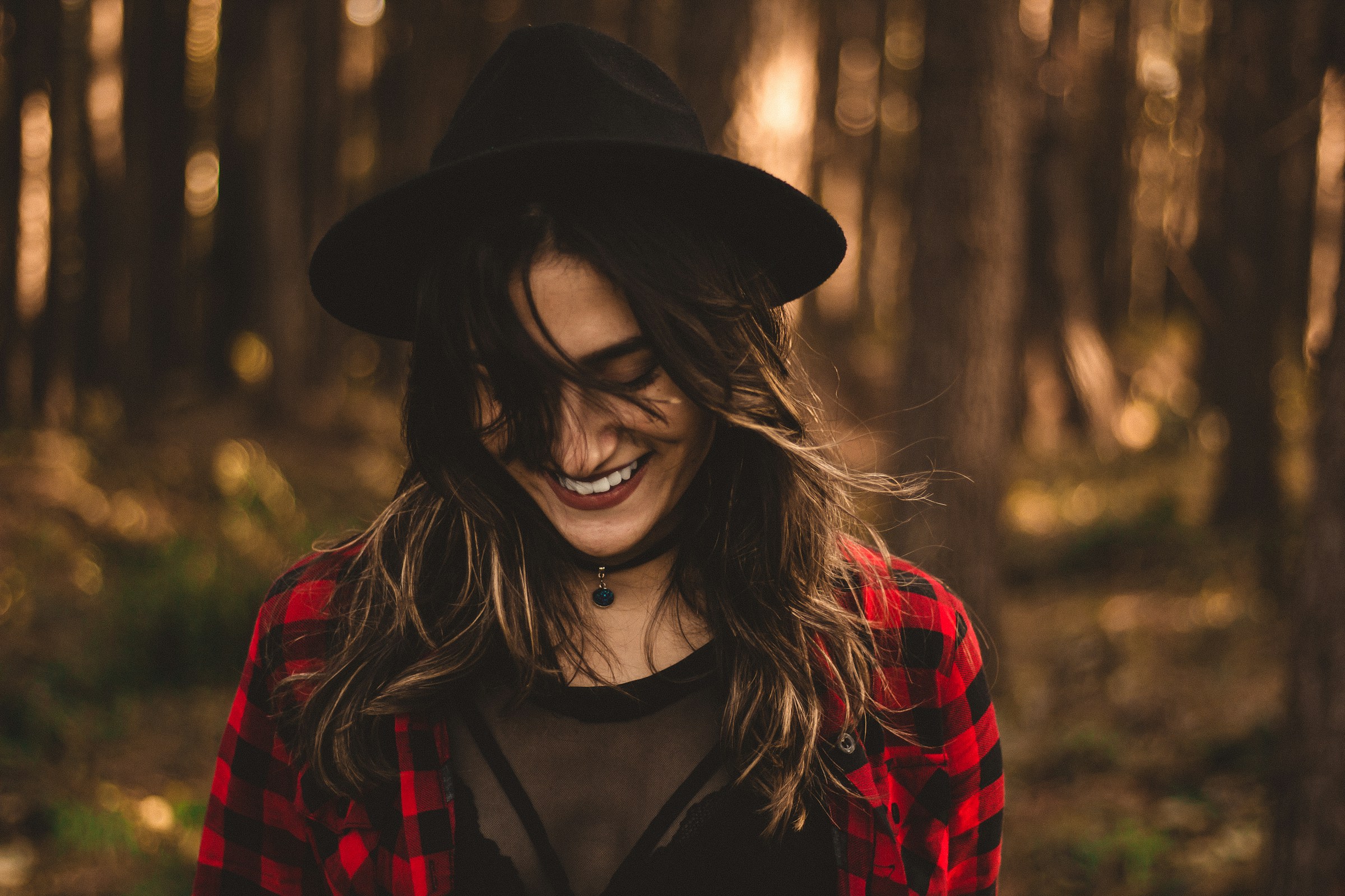 Mujer sonriendo en el bosque | Foto: Unsplash
