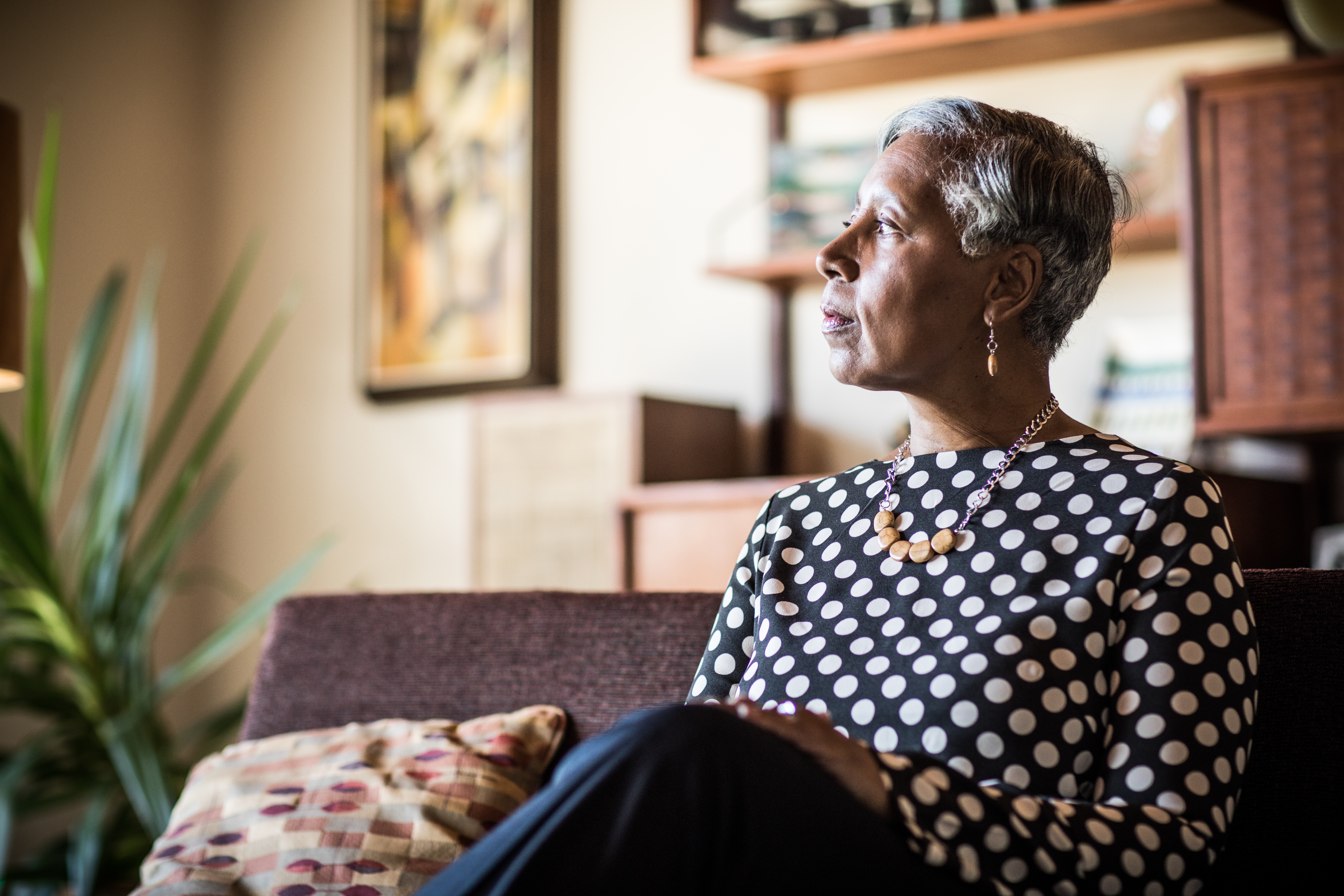 Retrato de mujer (60 años) sentada en el sofá de su casa | Foto: Getty Images