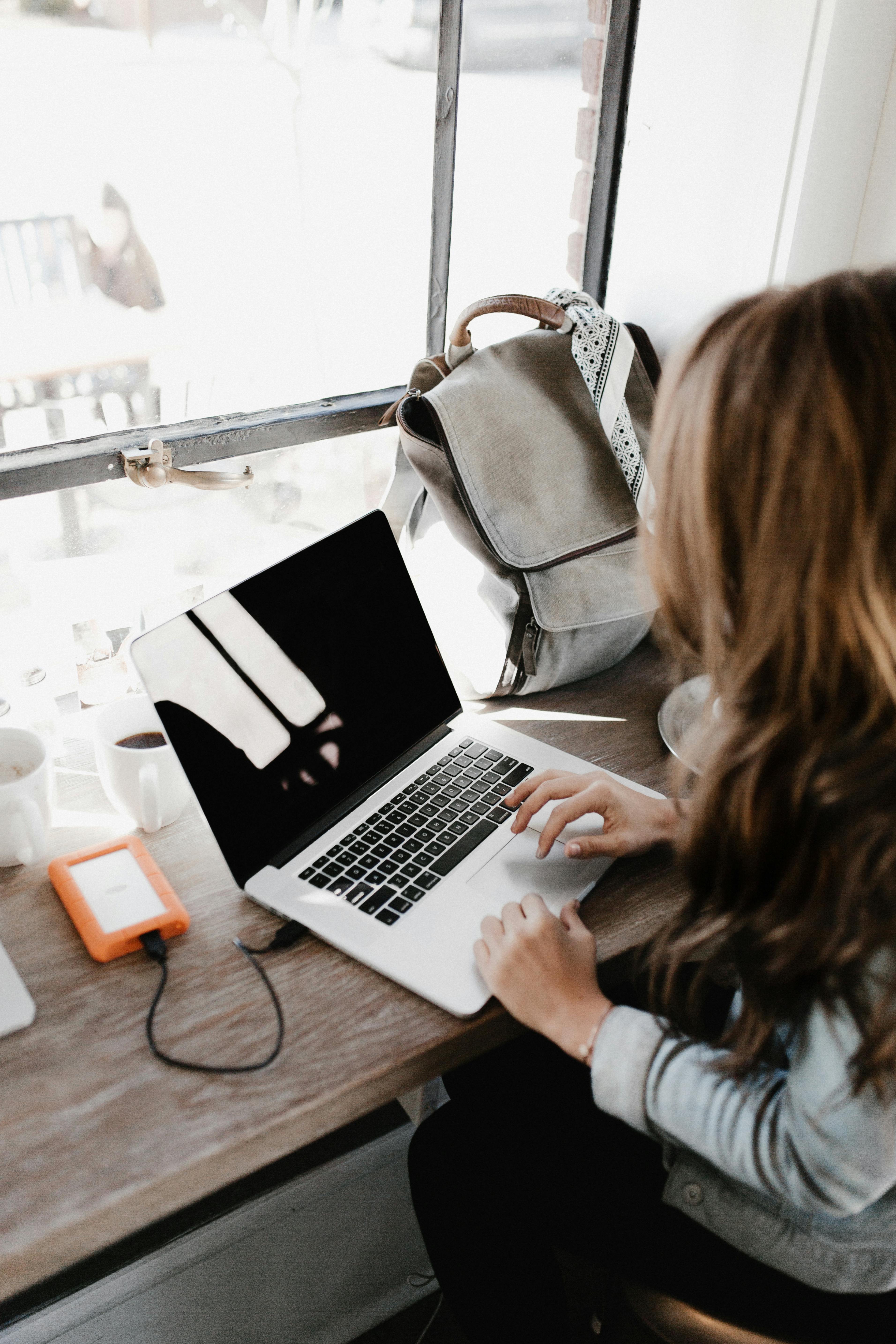 Una mujer con su portátil | Fuente: Pexels