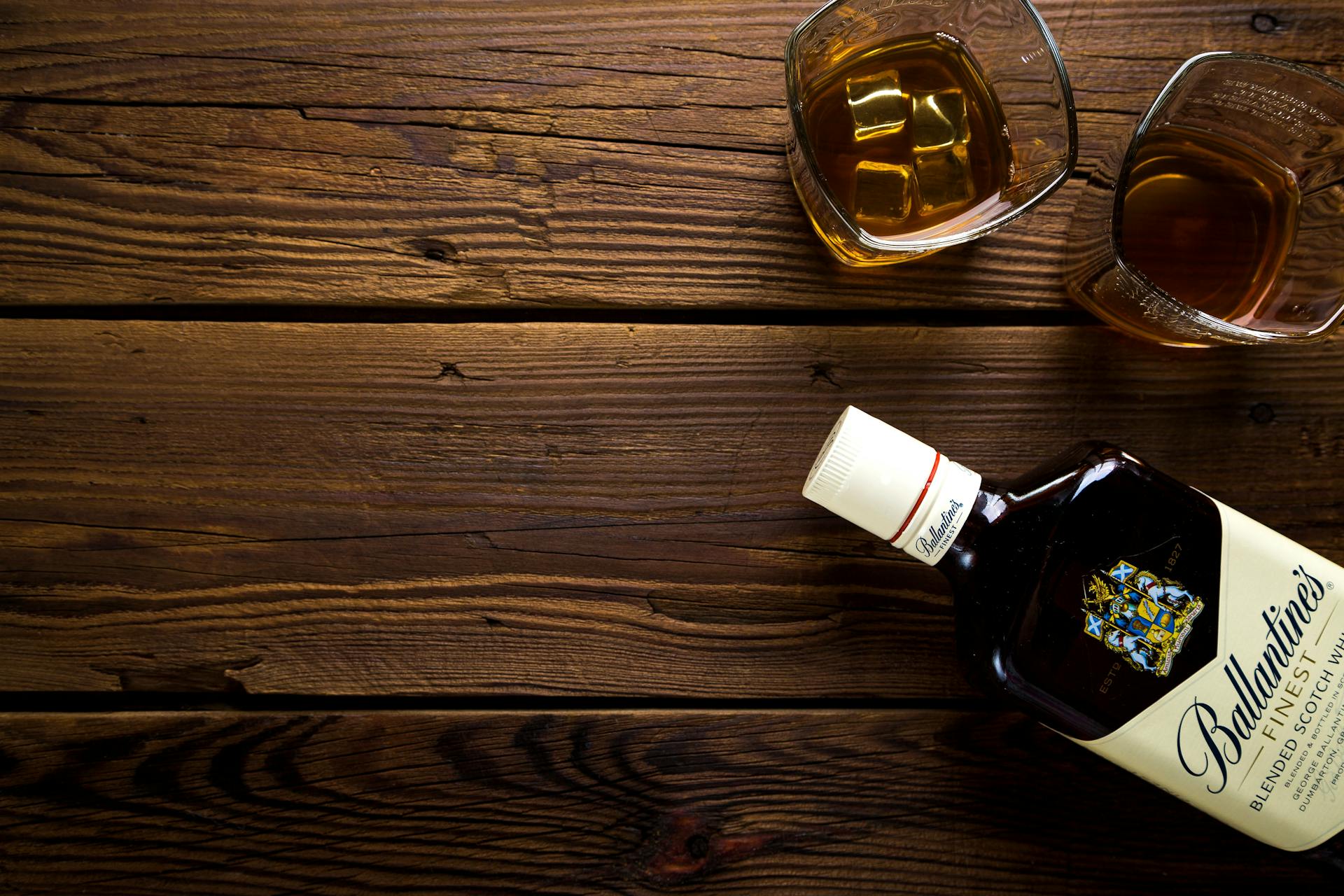 Dos vasos y una botella de licor sobre una mesa | Foto: Pexels