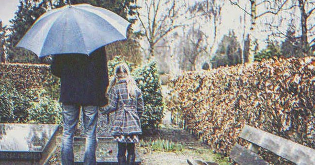 Un hombre y una niña con un paraguas | Foto: Shutterstock
