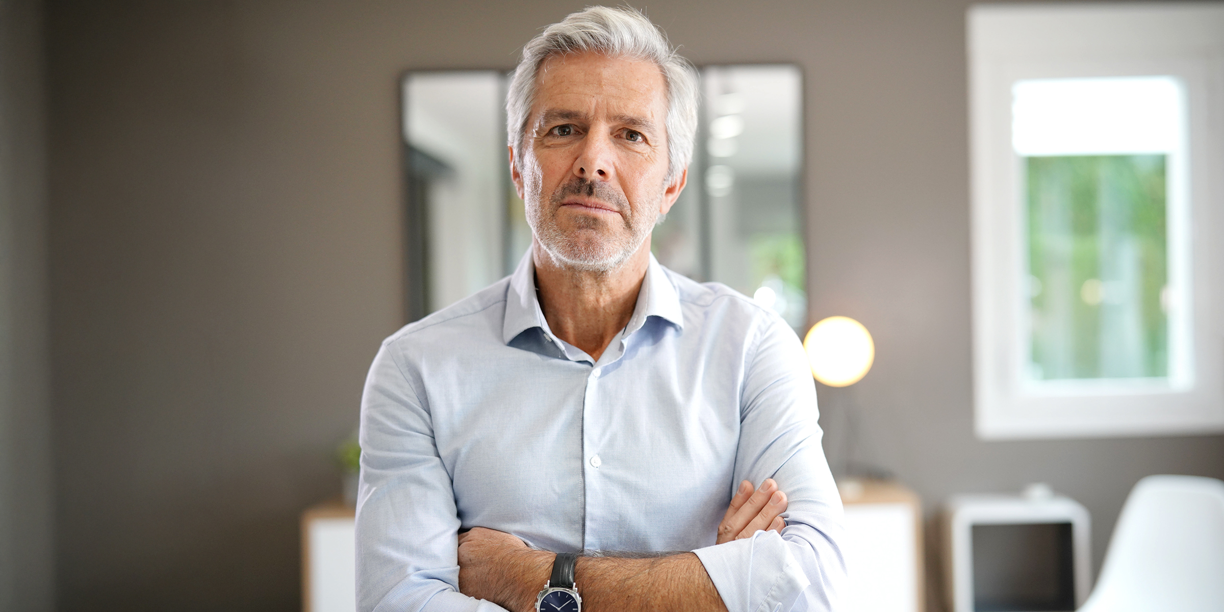 Un hombre de pie con los brazos cruzados | Fuente: Shutterstock