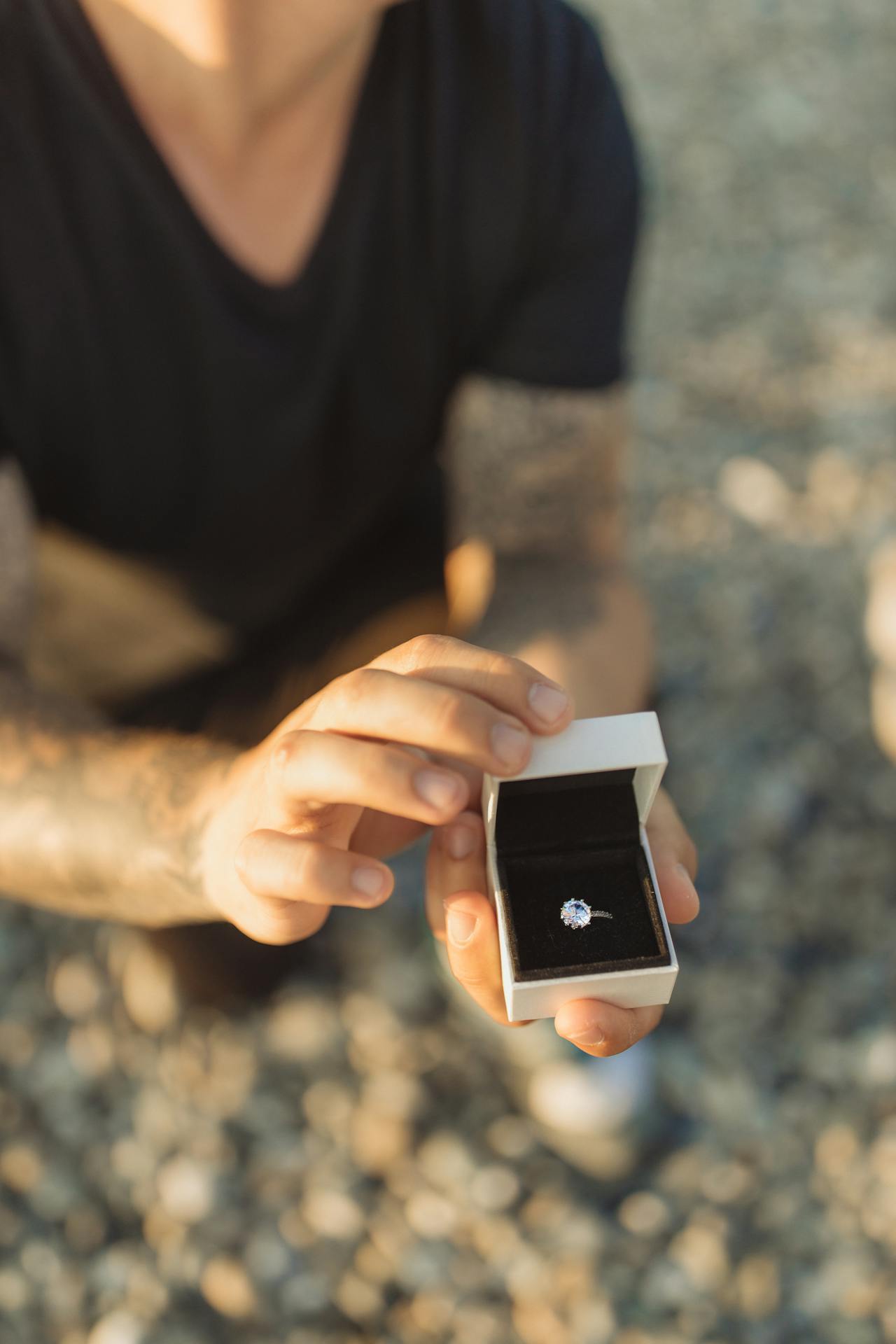 Un hombre arrodillado con una caja de anillos en la mano | Fuente: Pexels