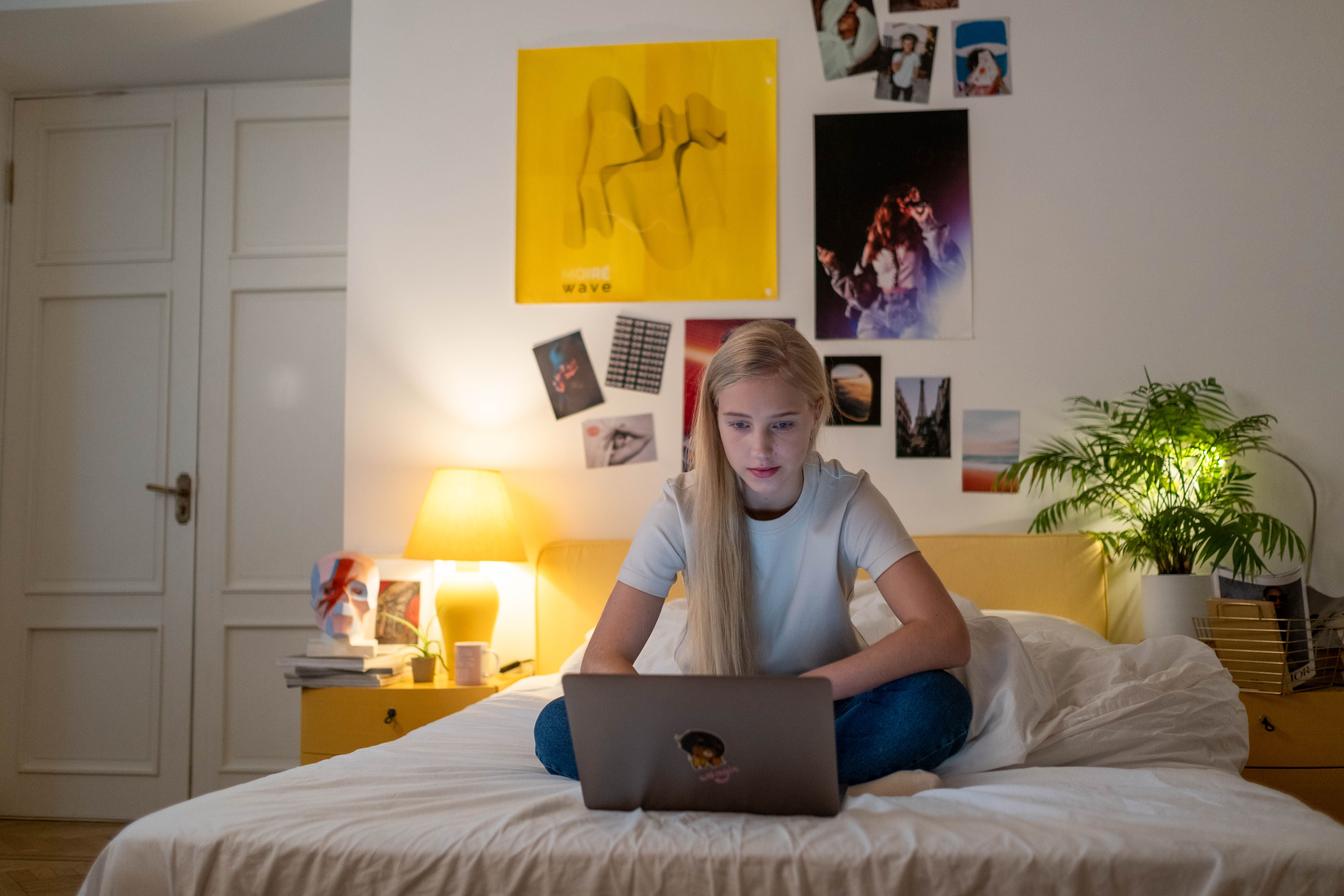 Una adolescente usando un portátil en su habitación | Fuente: Pexels