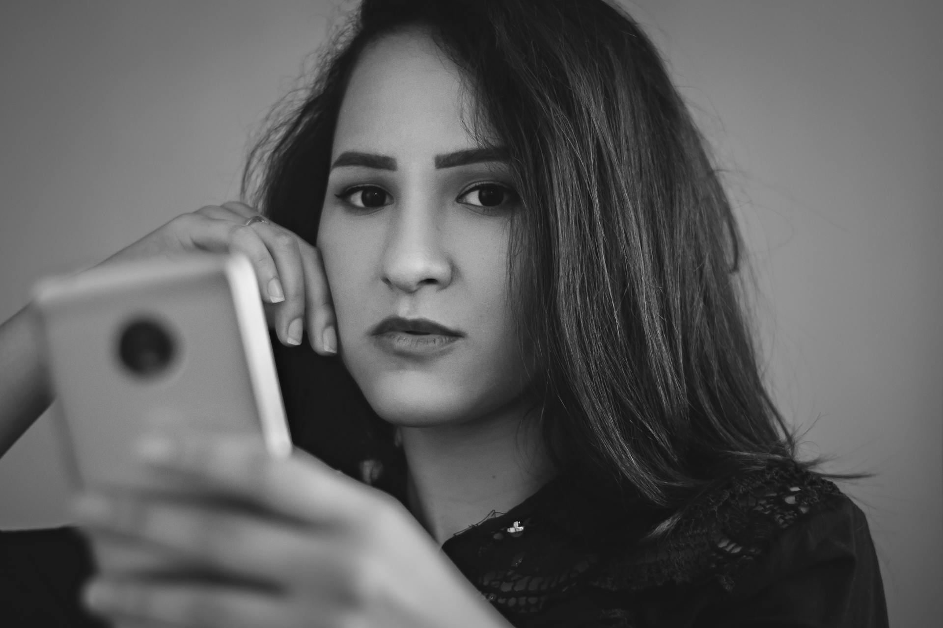 Una mujer desinteresada sujetando un teléfono | Fuente: Pexels