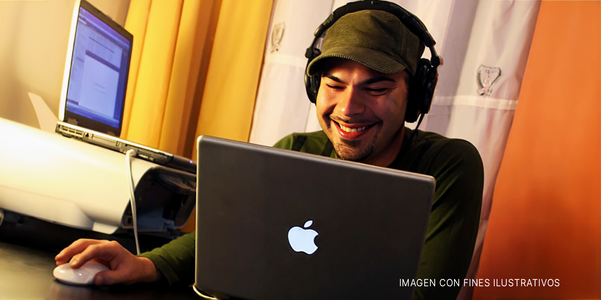 Hombre con auriculares sonriendo ante un portátil | Foto: Flickr.com/Looking Glass (CC BY-SA 2.0)