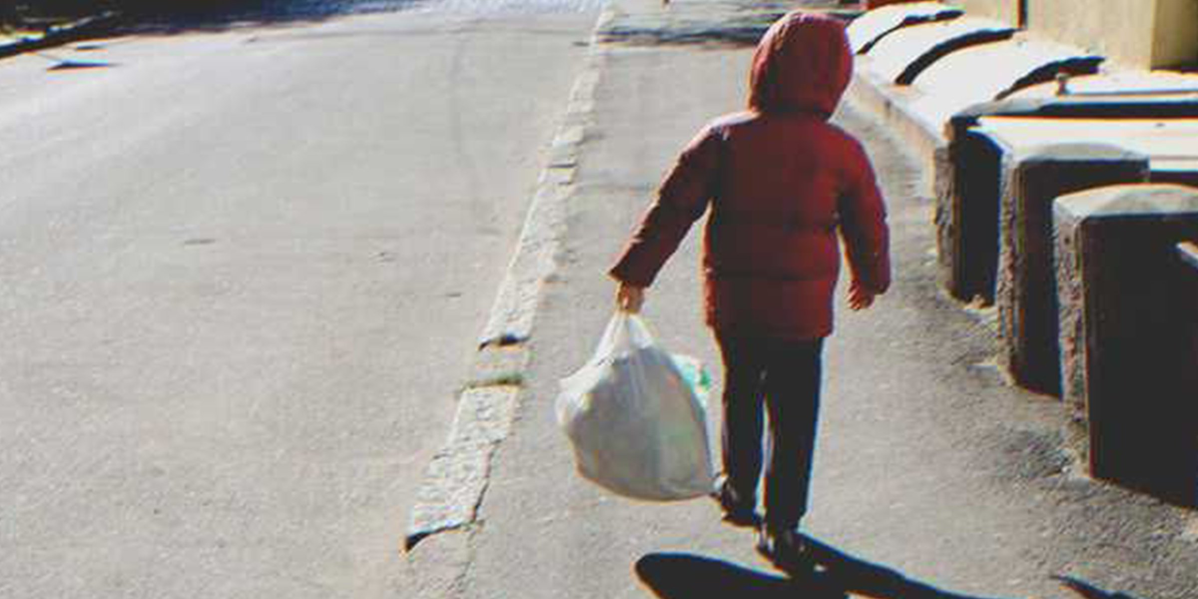 Un niño con una bolsa en la calle | Foto: Shutterstock