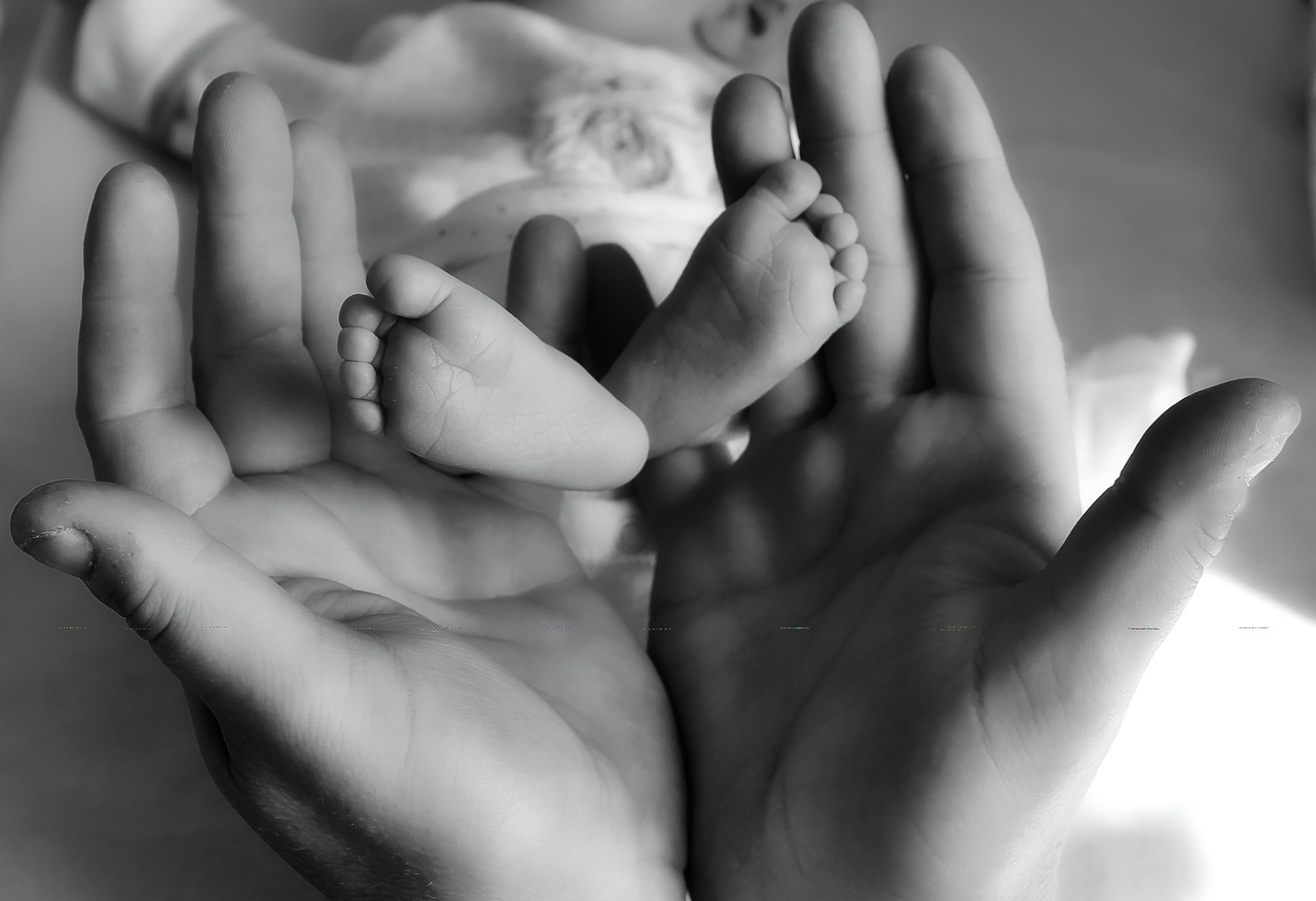 Mujer sujeta los pies de un recién nacido | Foto: Pixabay
