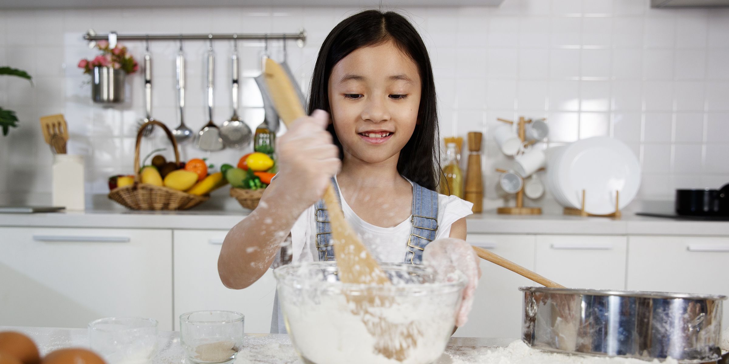 Una niña mezclando harina en un cuenco | Fuente: Shutterstock