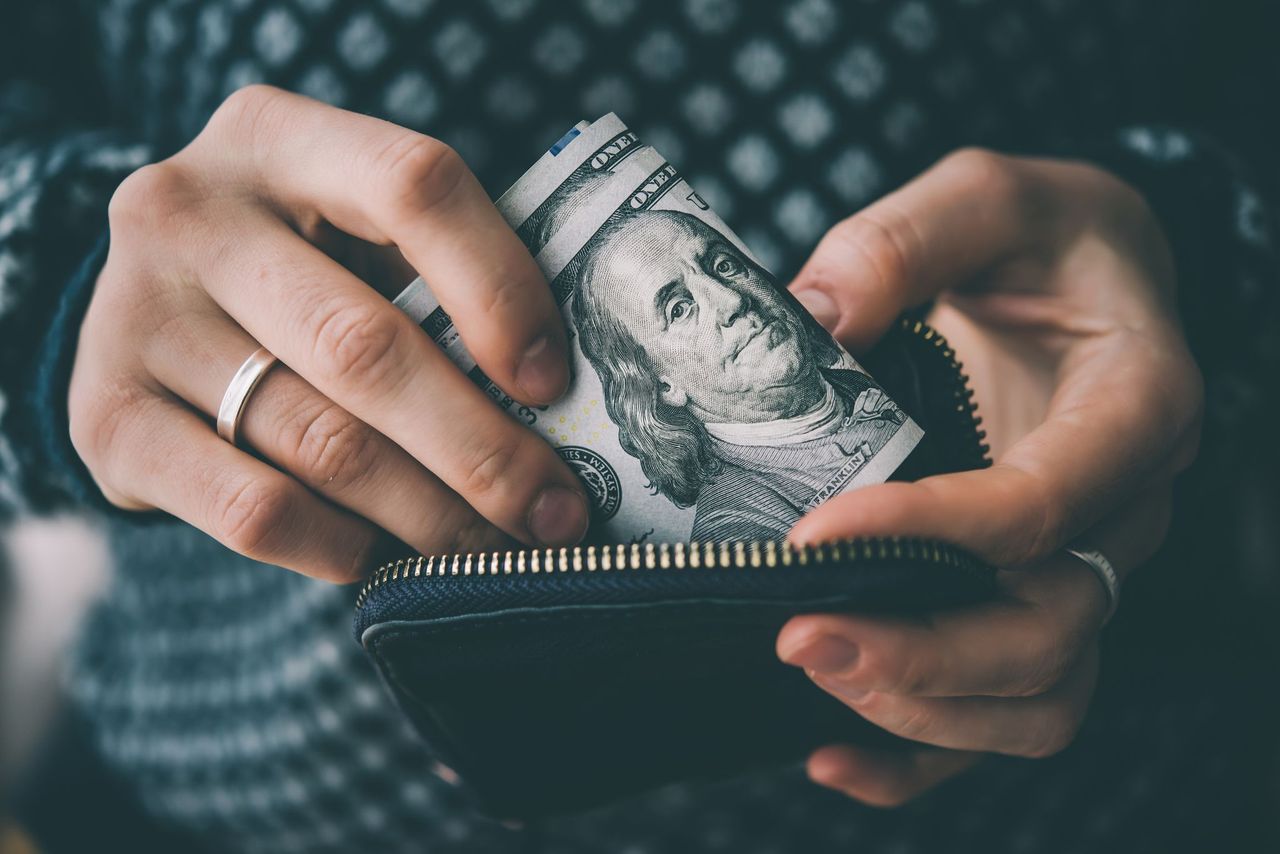 Hombre sacando dinero de su billetera. | Foto: Shutterstock