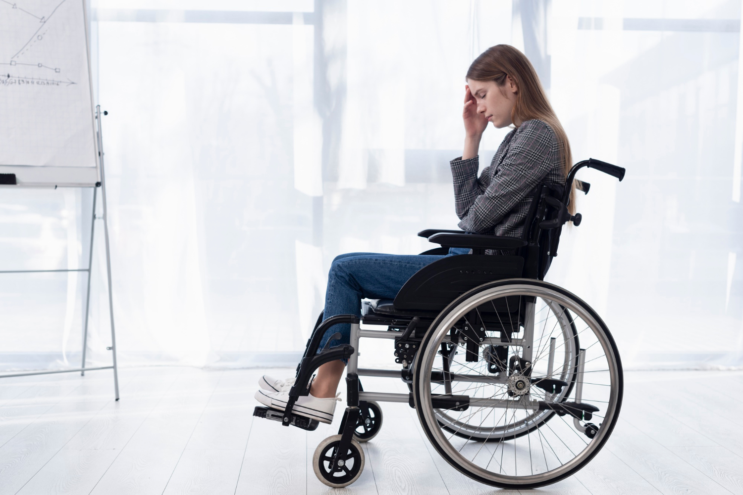 Una mujer angustiada sentada en una silla de ruedas | Fuente: Freepik