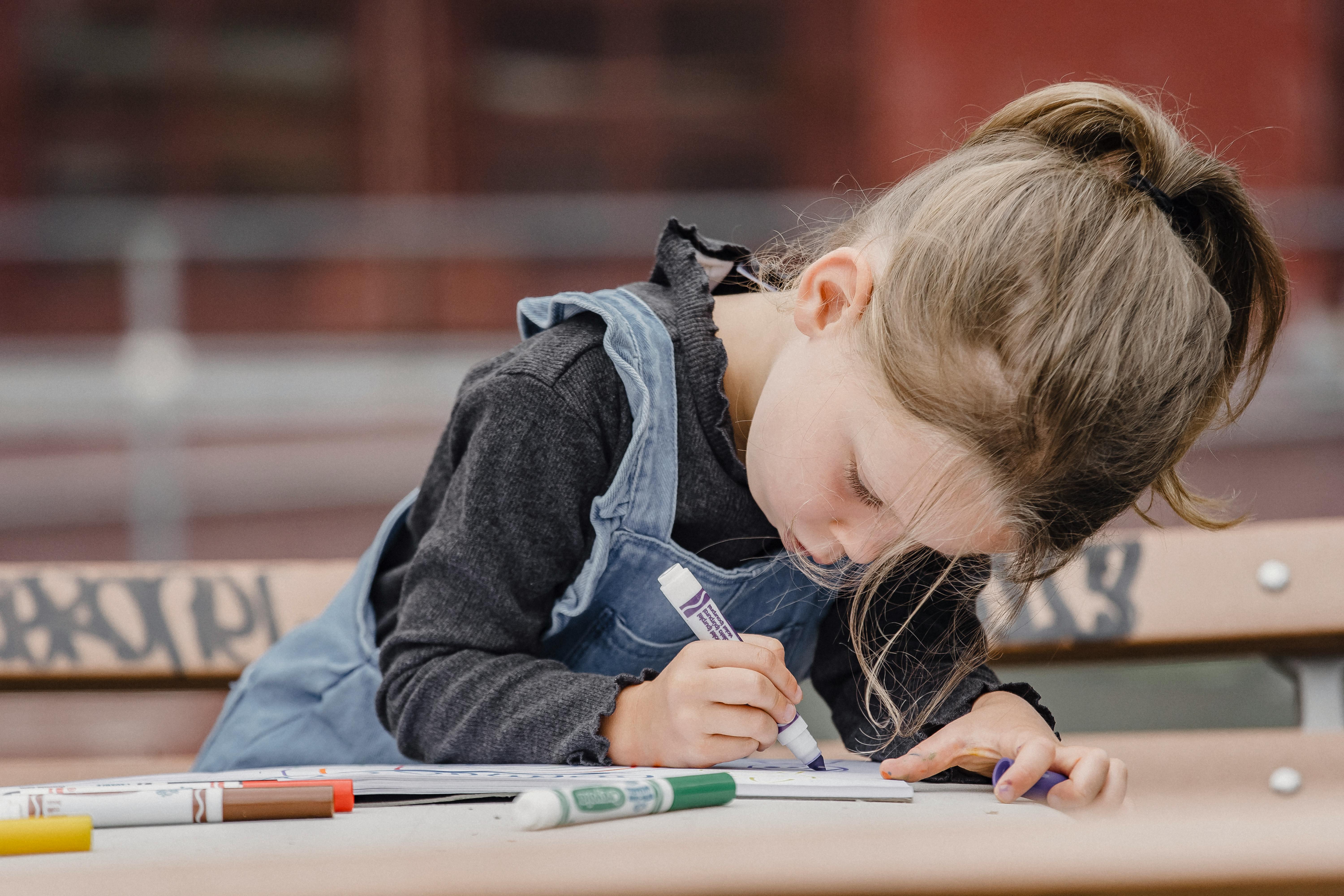 Una niña coloreando en su libro | Fuente: Pexels