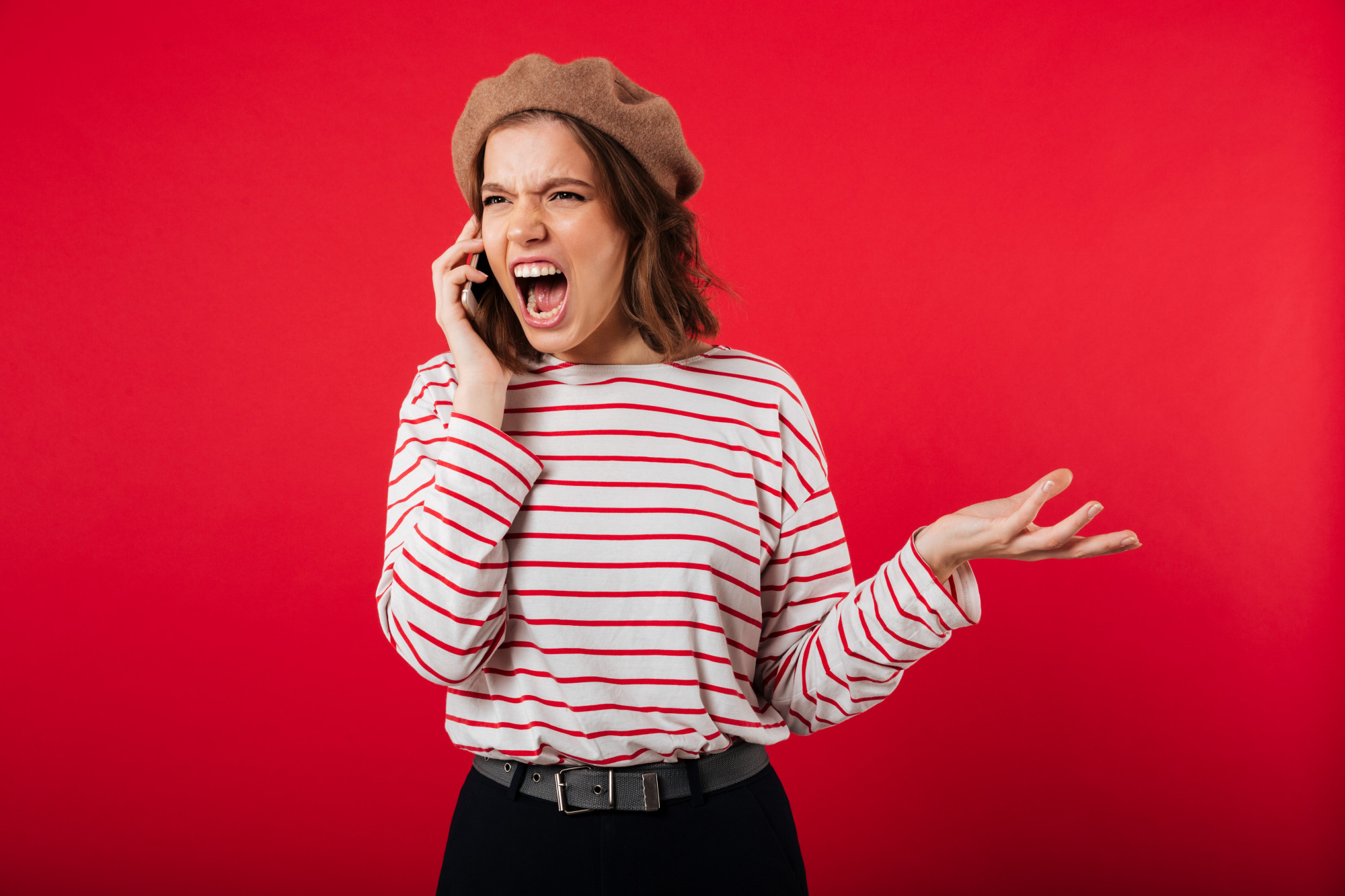Una mujer enfadada gritando en una llamada telefónica | Foto: Freepik