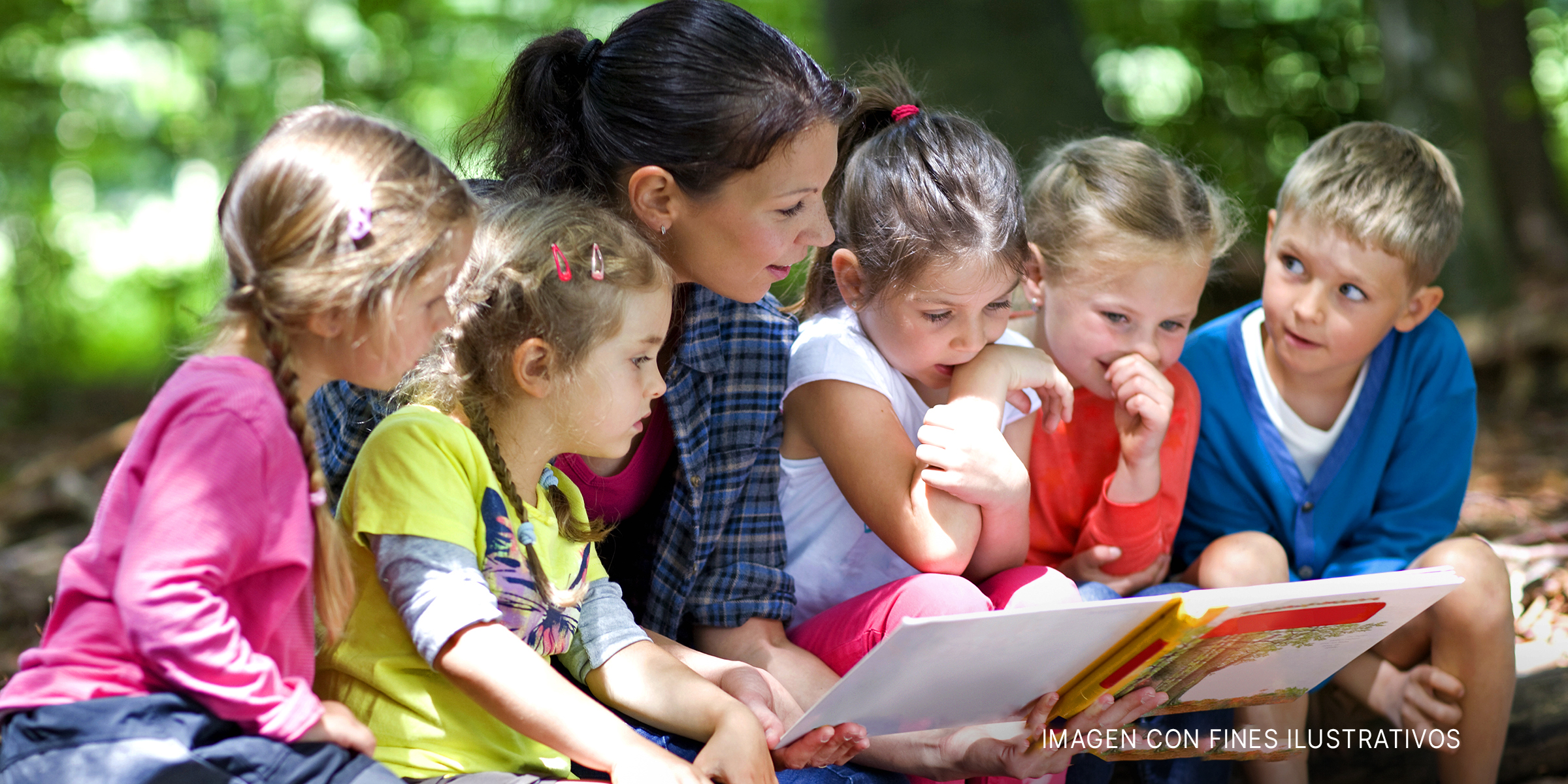 Mujer leyendo un libro a niños pequeños | Foto: Shutterstock