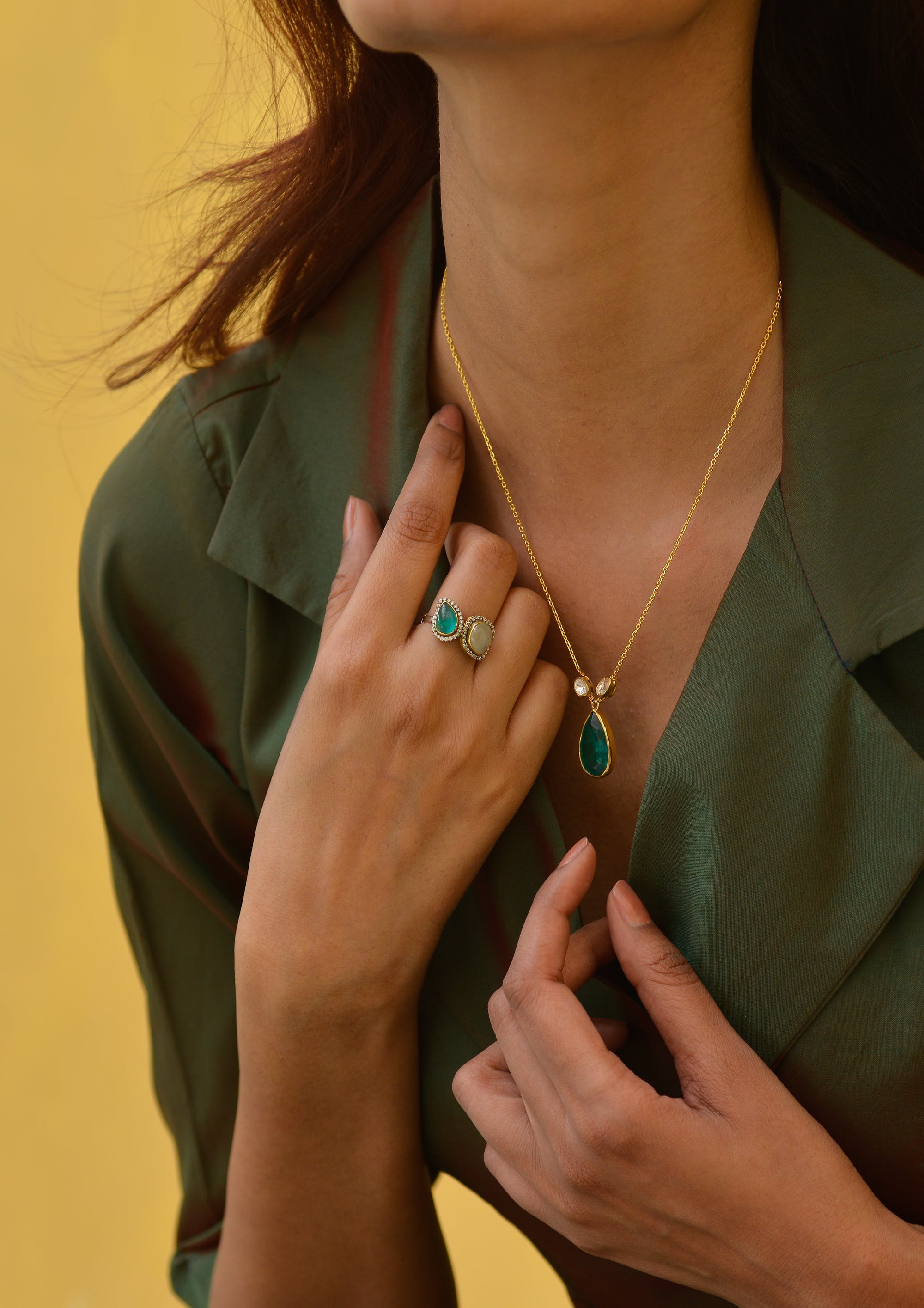 Mujer con colgante y anillo de esmeralda | Foto: Pexels