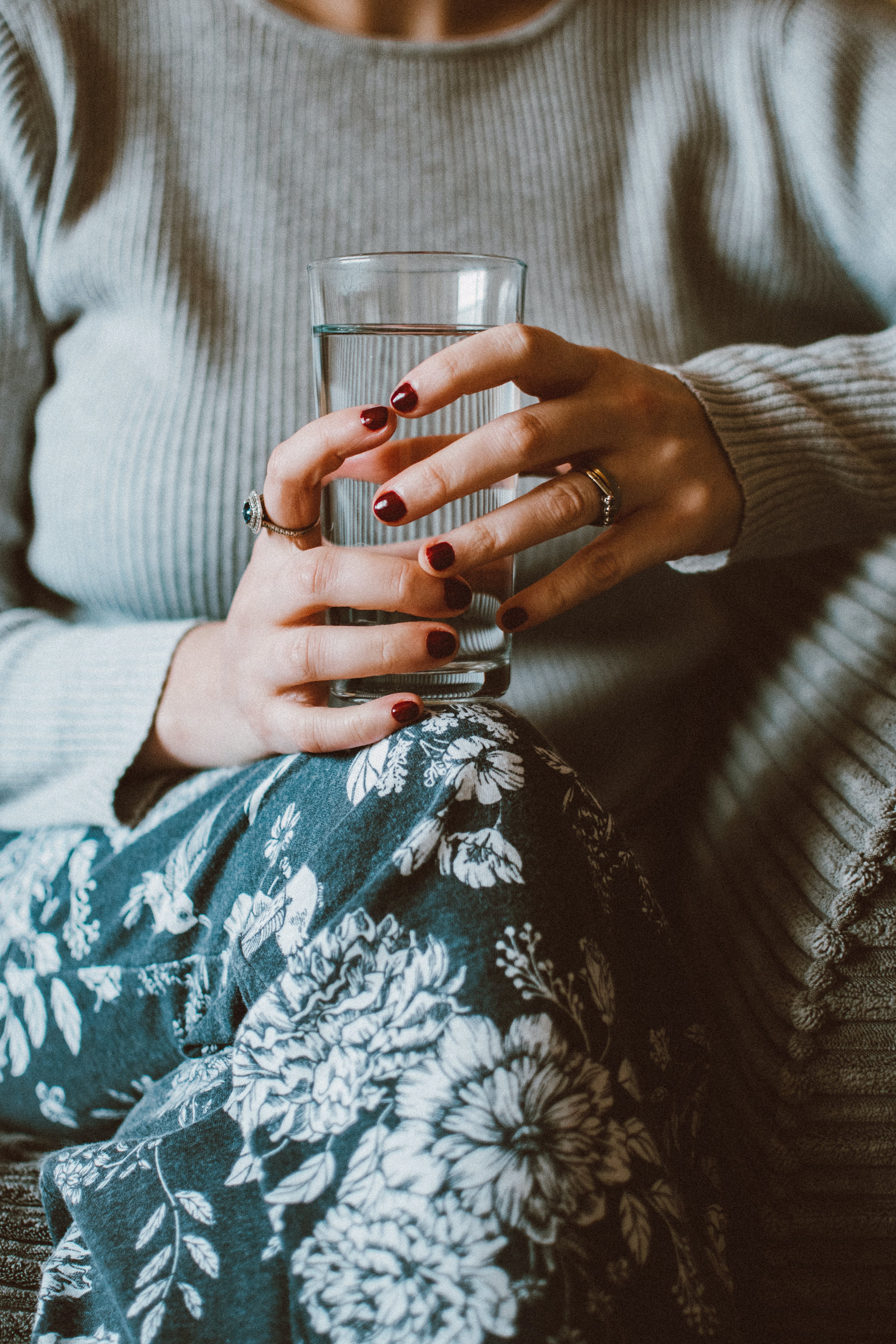 Una persona con un vaso de agua en la mano. | Fuente: Pexels