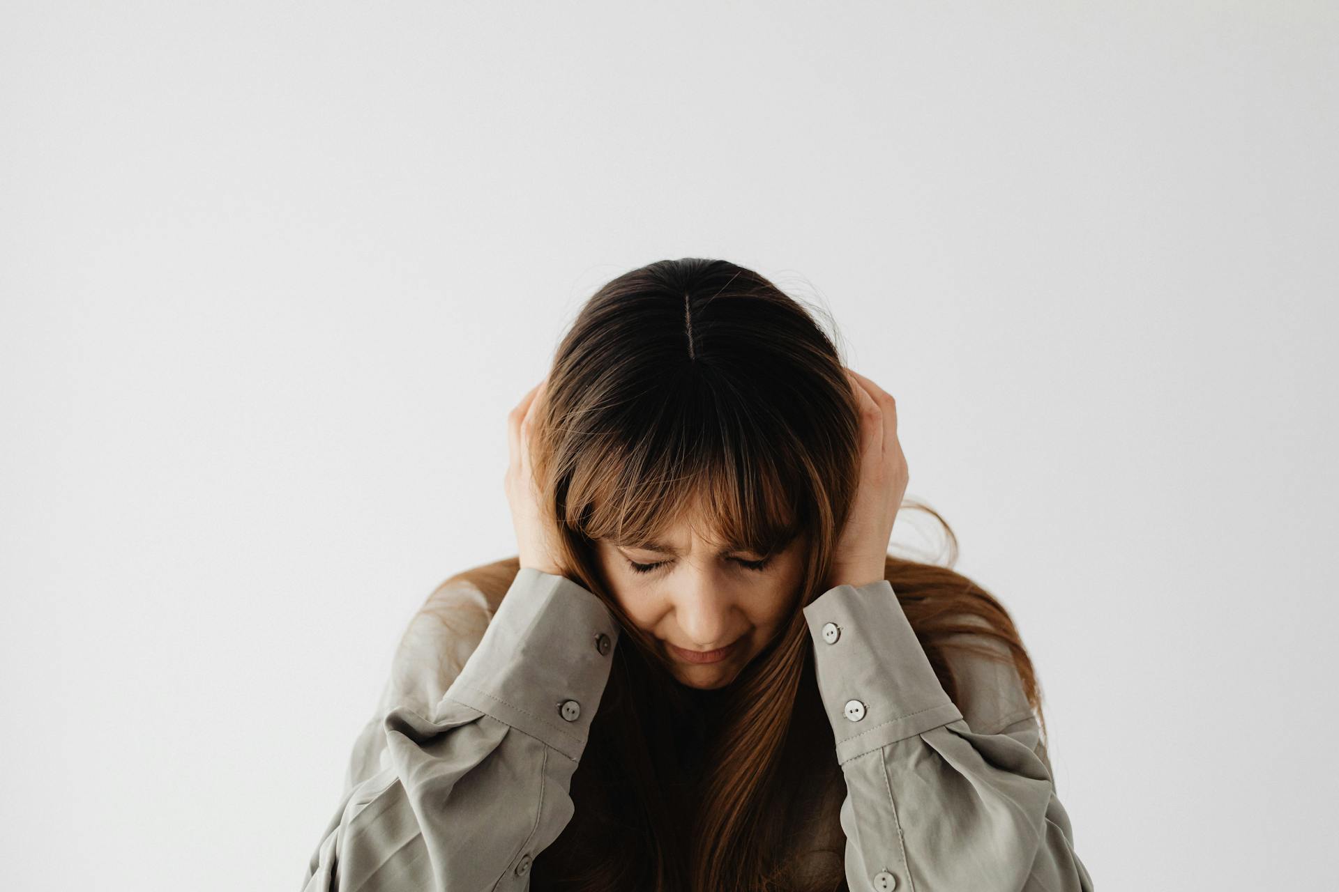 Una mujer triste sentada con la cabeza entre las manos | Fuente: Pexels