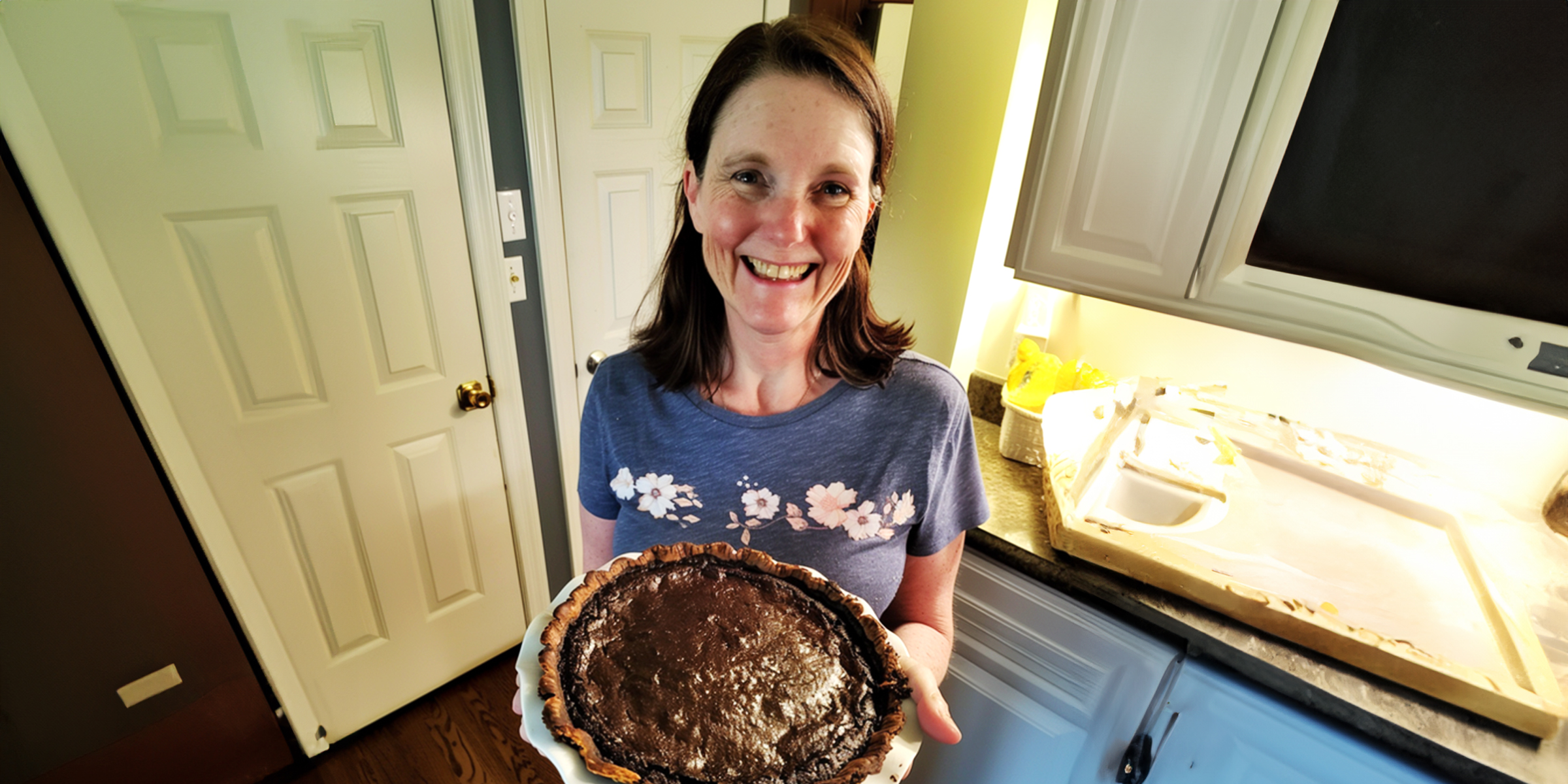 Una mujer con una tarta de chocolate en la mano | Fuente: AmoMama