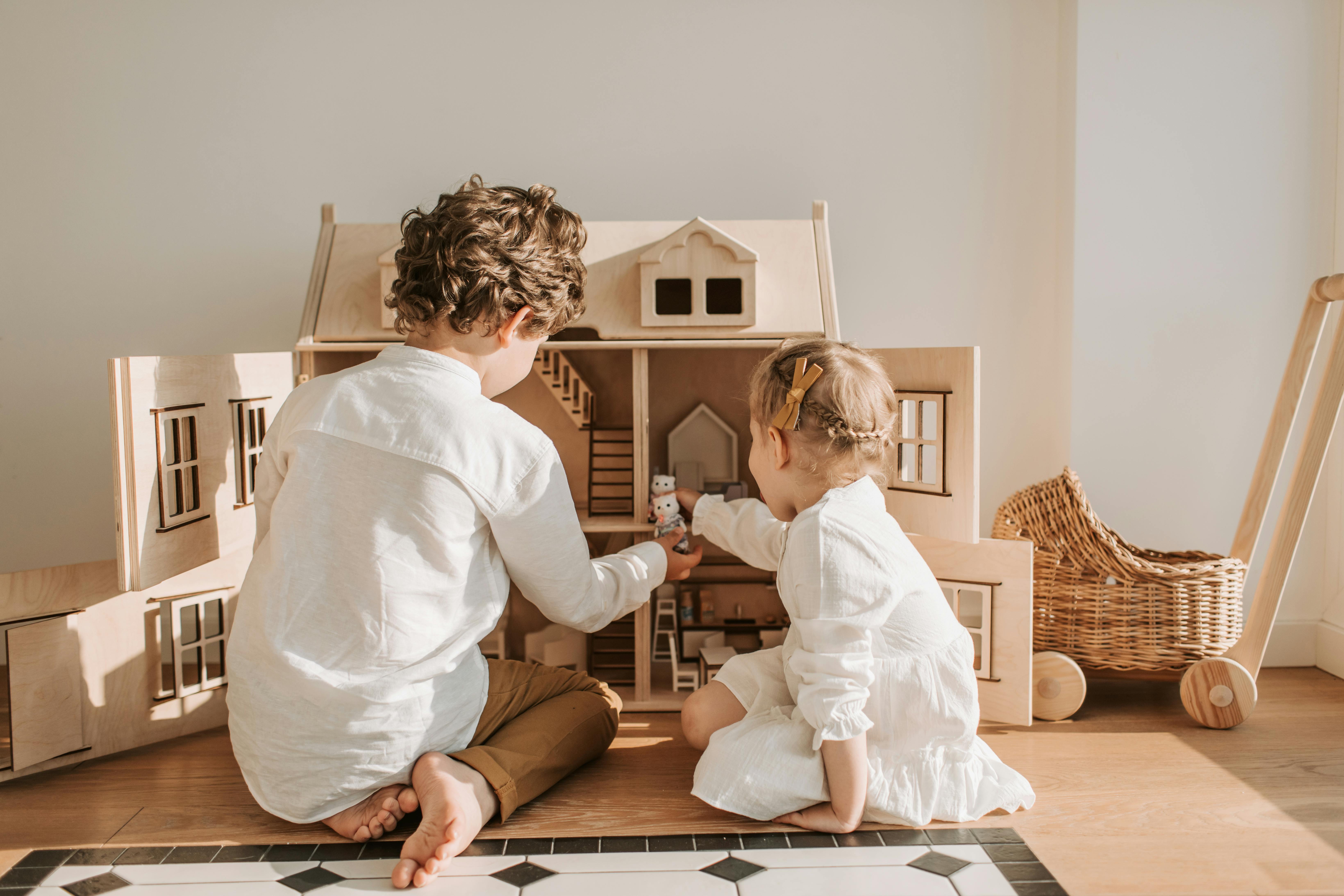 Dos niños jugando con una casa de muñecas | Fuente: Pexels