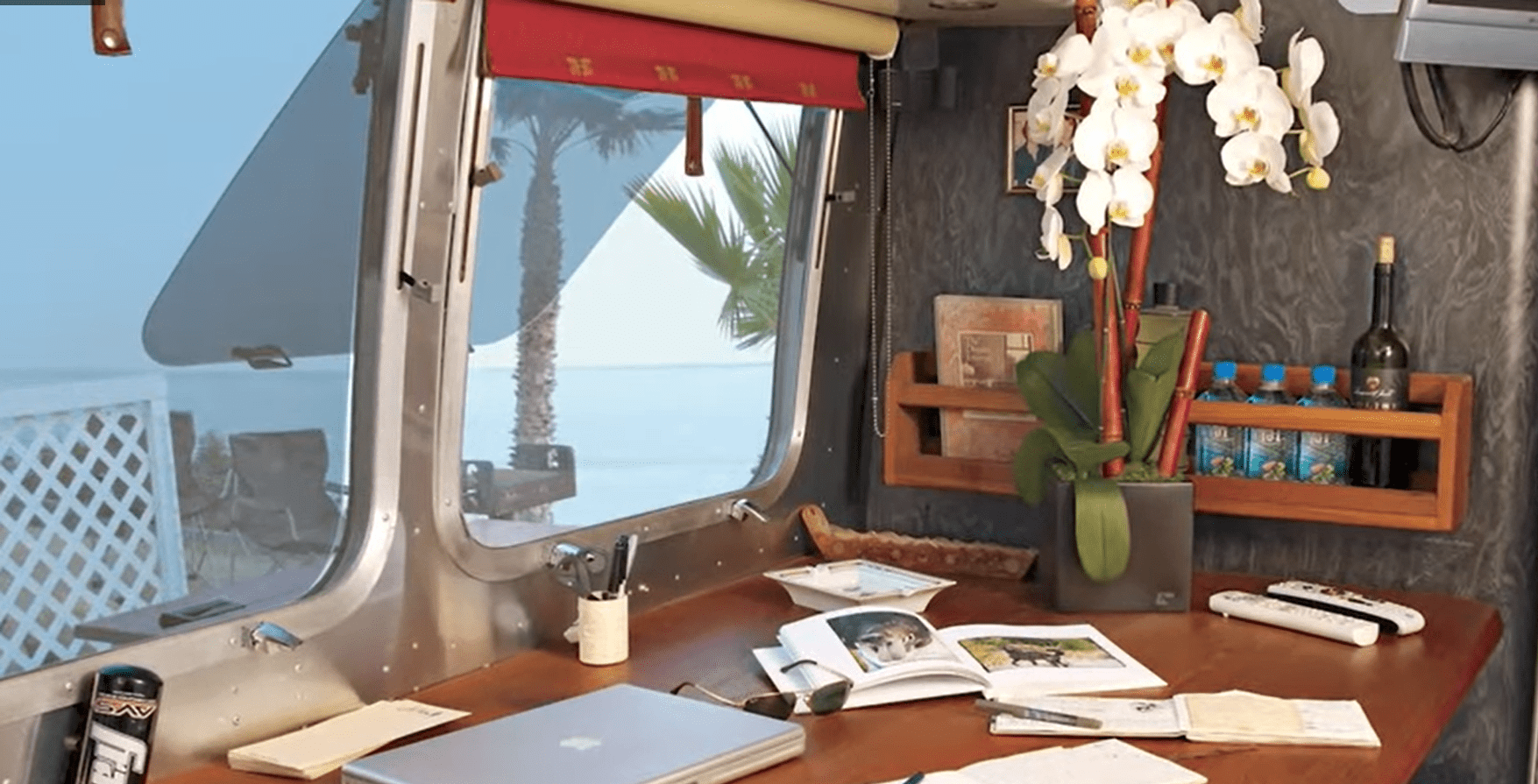 Un escritorio y ventanas en el interior de la caravana Airstream | Fuente: YouTube/Famous Entertainment