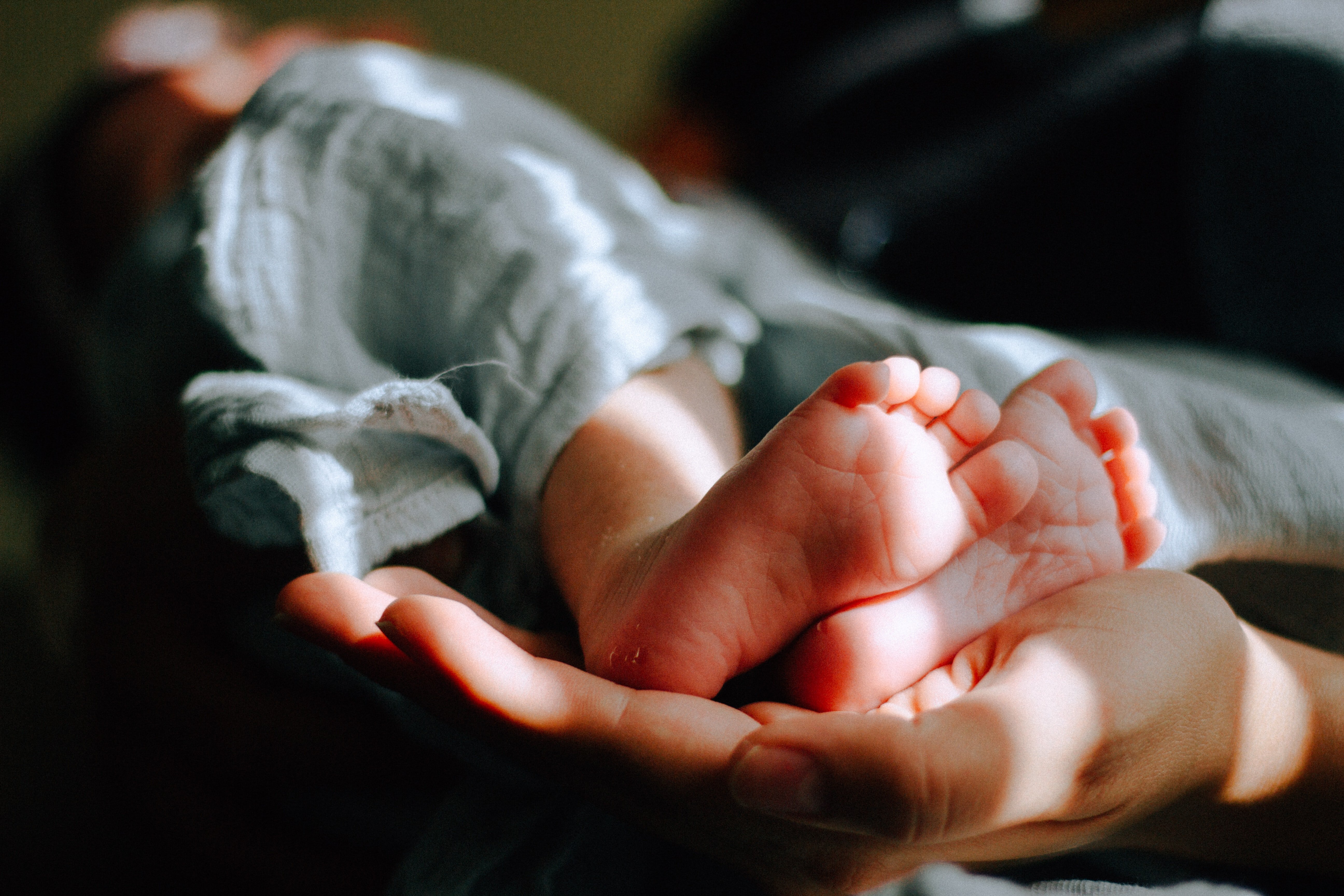 Una persona sosteniendo los pies de un bebé recién nacido. | Foto: Unsplash