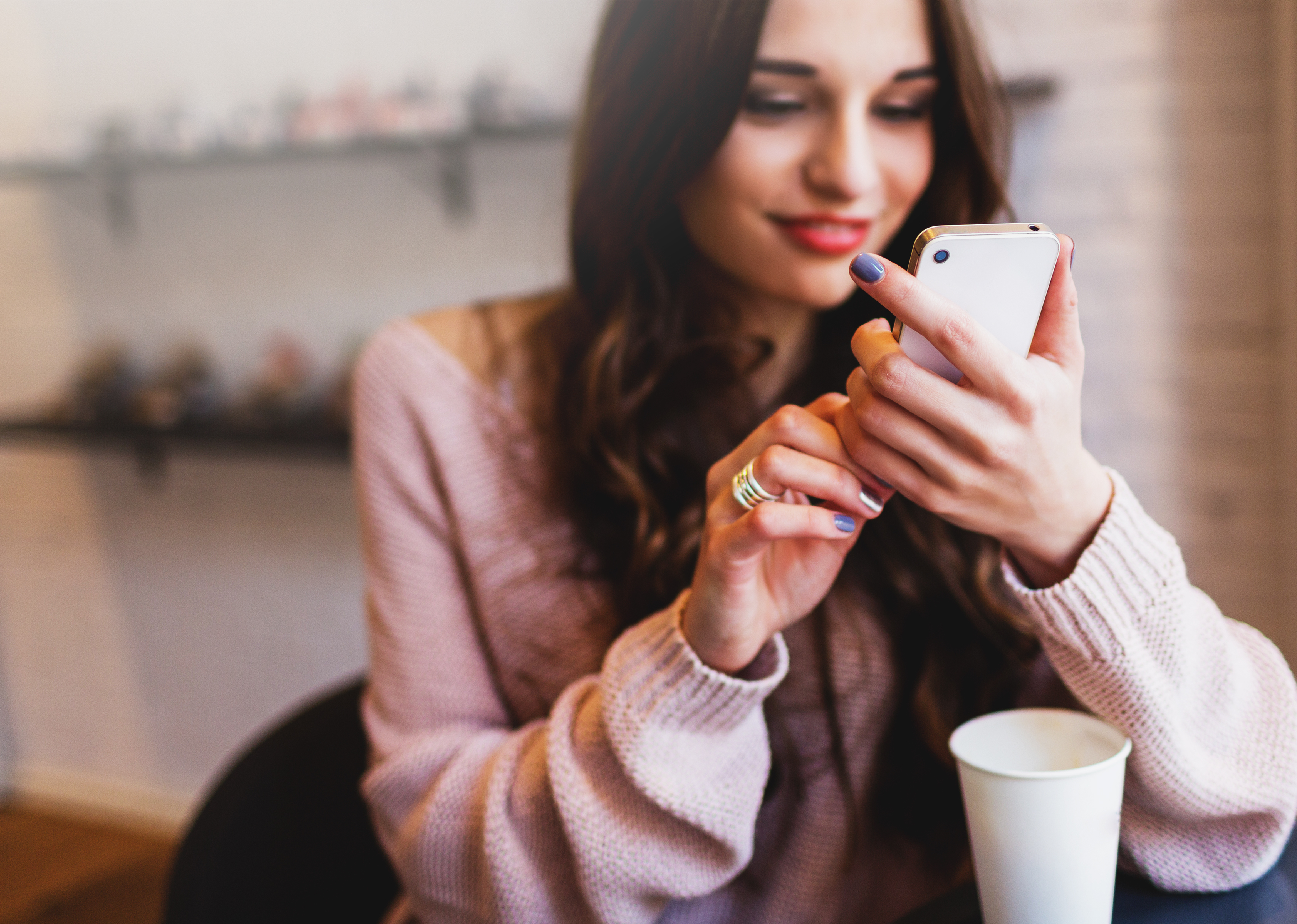 Una mujer feliz consultando su teléfono | Foto: Shutterstock