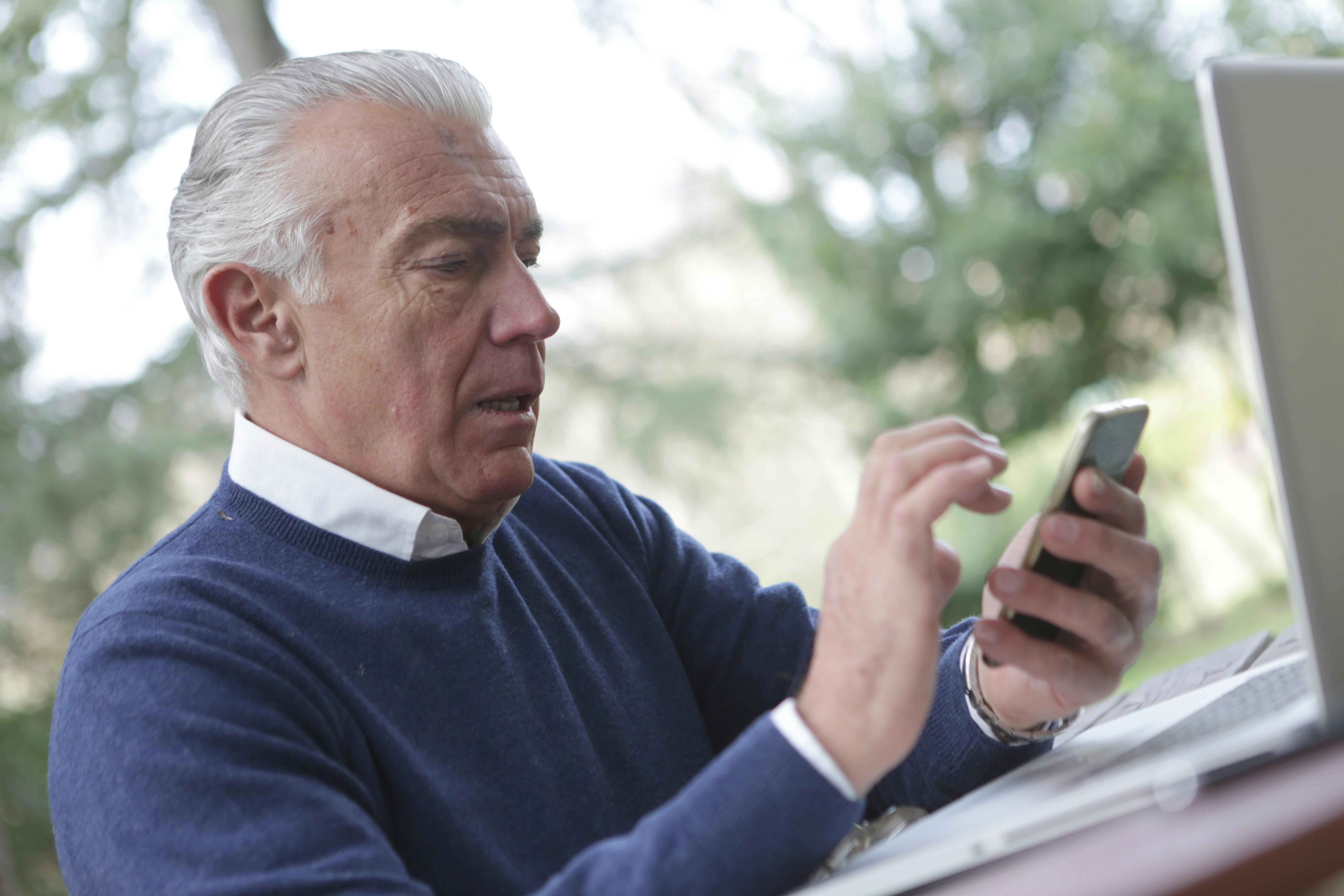 Un hombre de aspecto neutro leyendo algo en su teléfono | Foto: Pexels