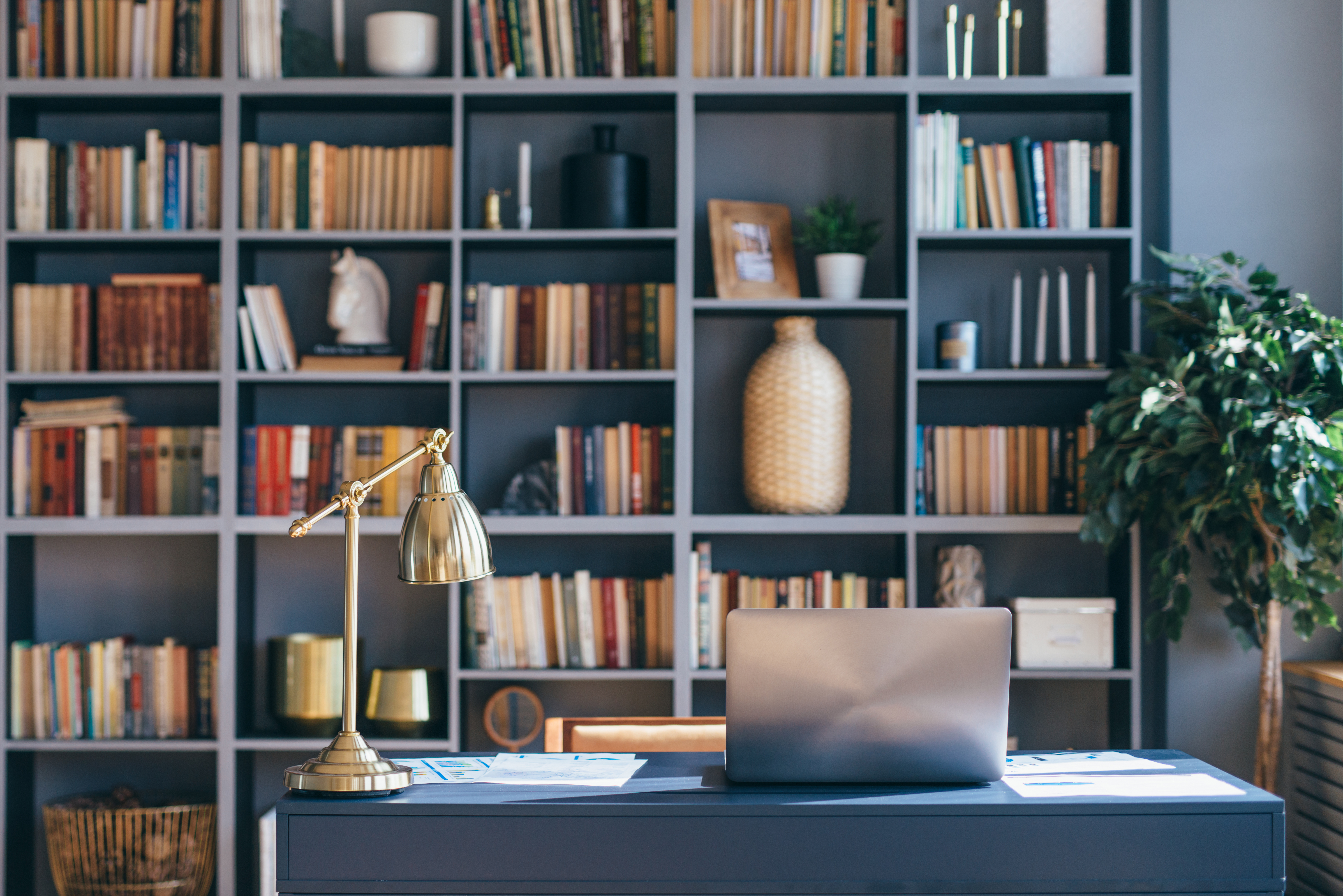 Un despacho privado en casa con un portátil y una estantería con libros | Foto: Shutterstock
