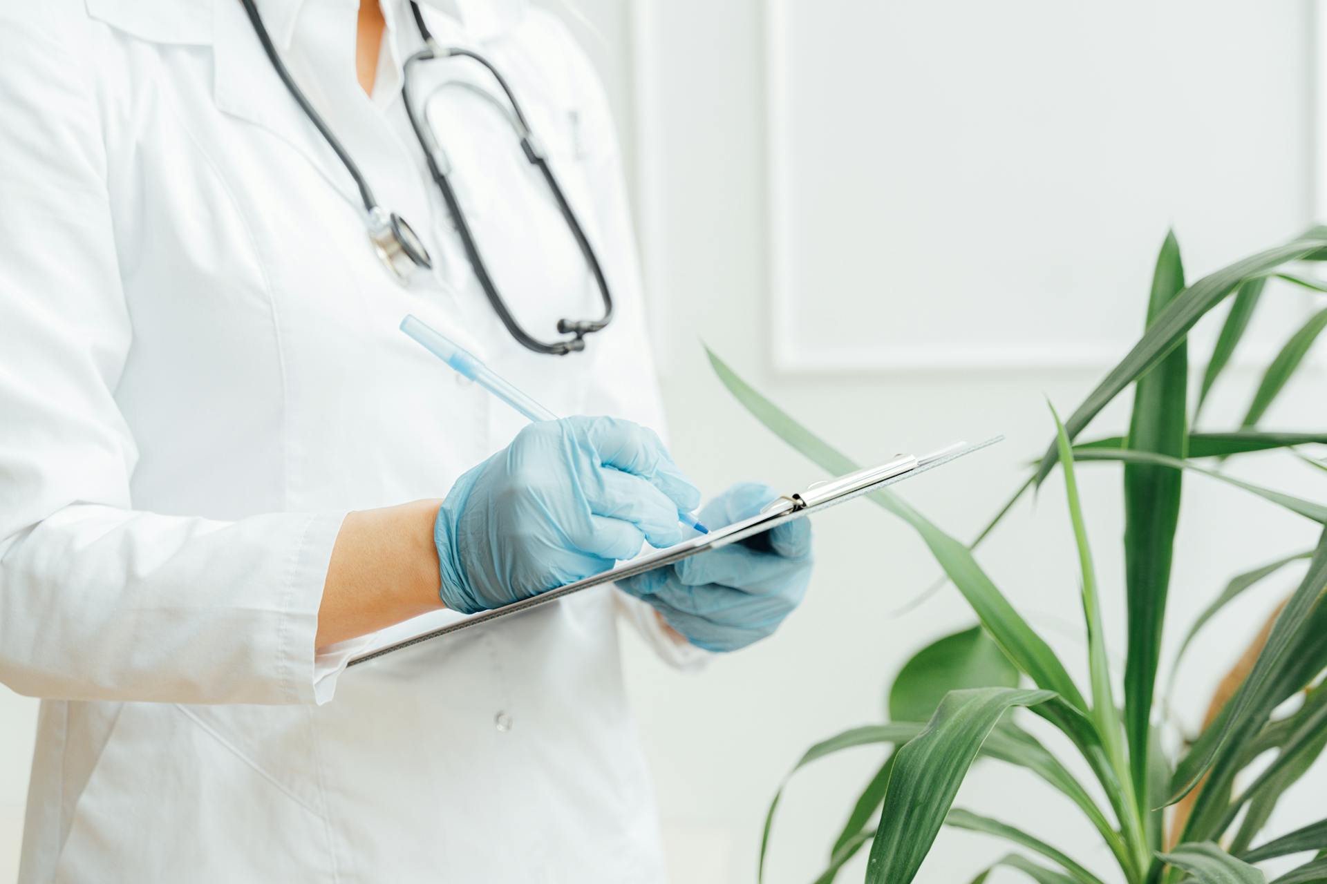 Un médico tomando notas en un portapapeles | Fuente: Pexels