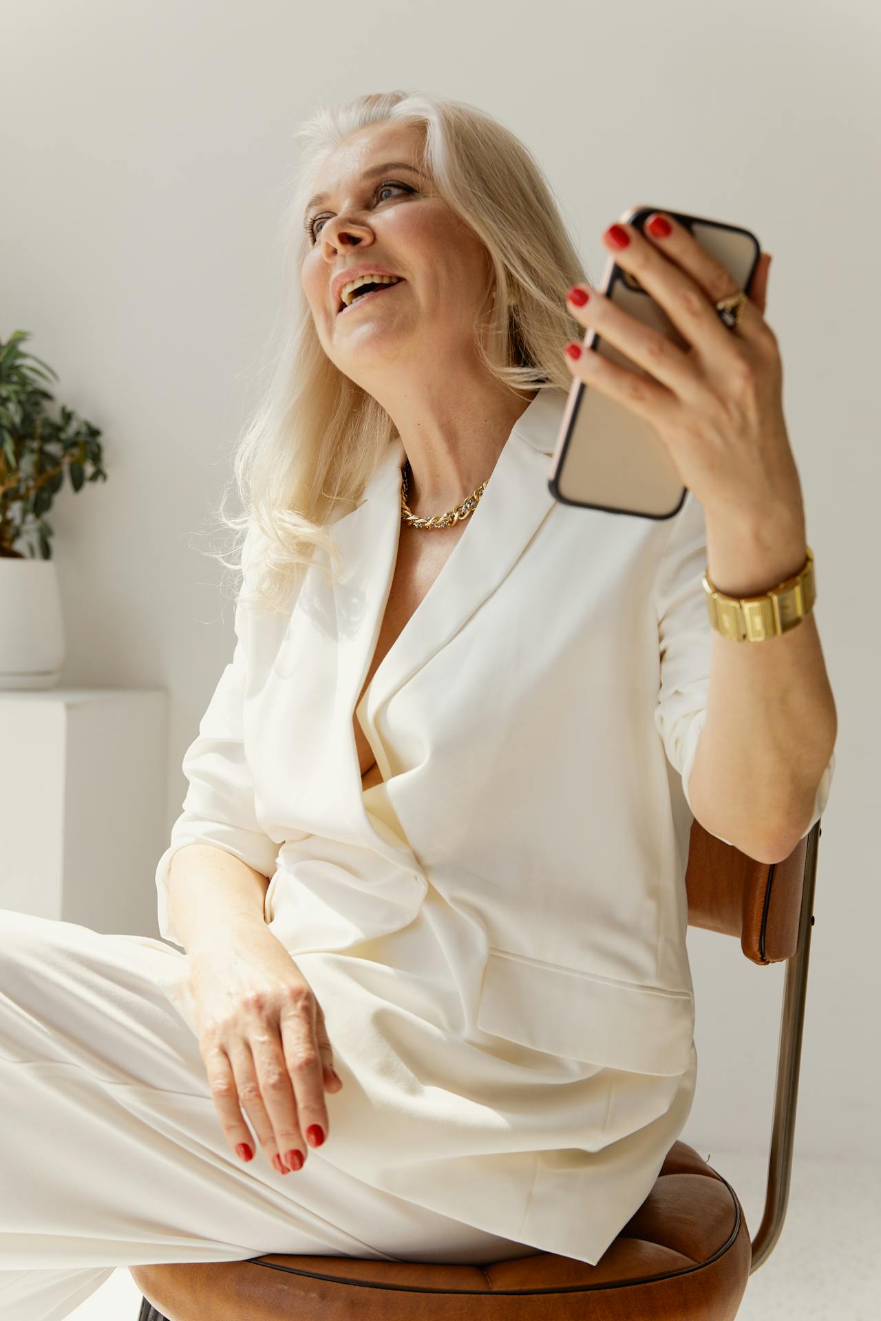 Una mujer mayor sonriente sosteniendo su teléfono | Fuente: Pexels