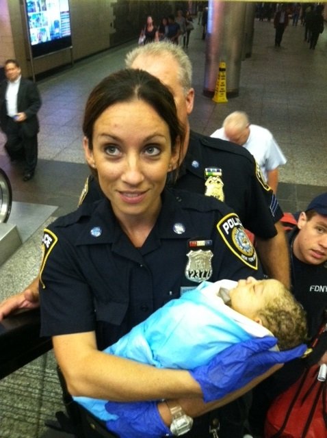Oficial de la policía sosteniendo un bebé en sus brazos. Imagen referencial. | Foto: Flickr