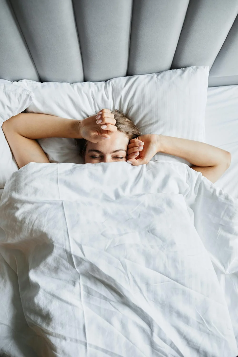 Una mujer relajándose en su cama | Fuente: Pexels