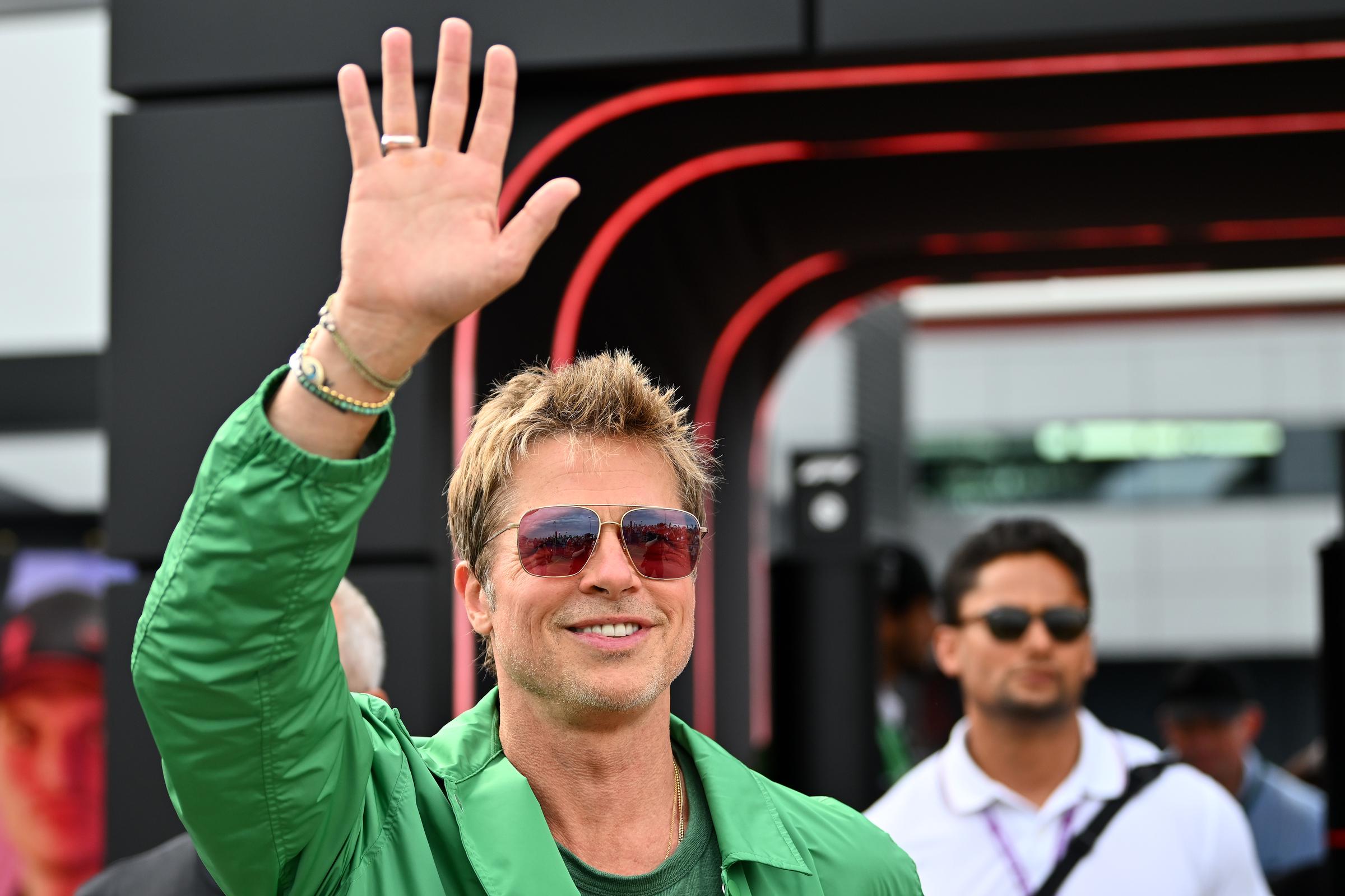 Brad Pitt saluda mientras camina por el Paddock después de la clasificación para el Gran Premio de F1 de Gran Bretaña en el circuito de Silverstone en Northampton, Inglaterra, el 8 de julio de 2023 | Fuente: Getty Images