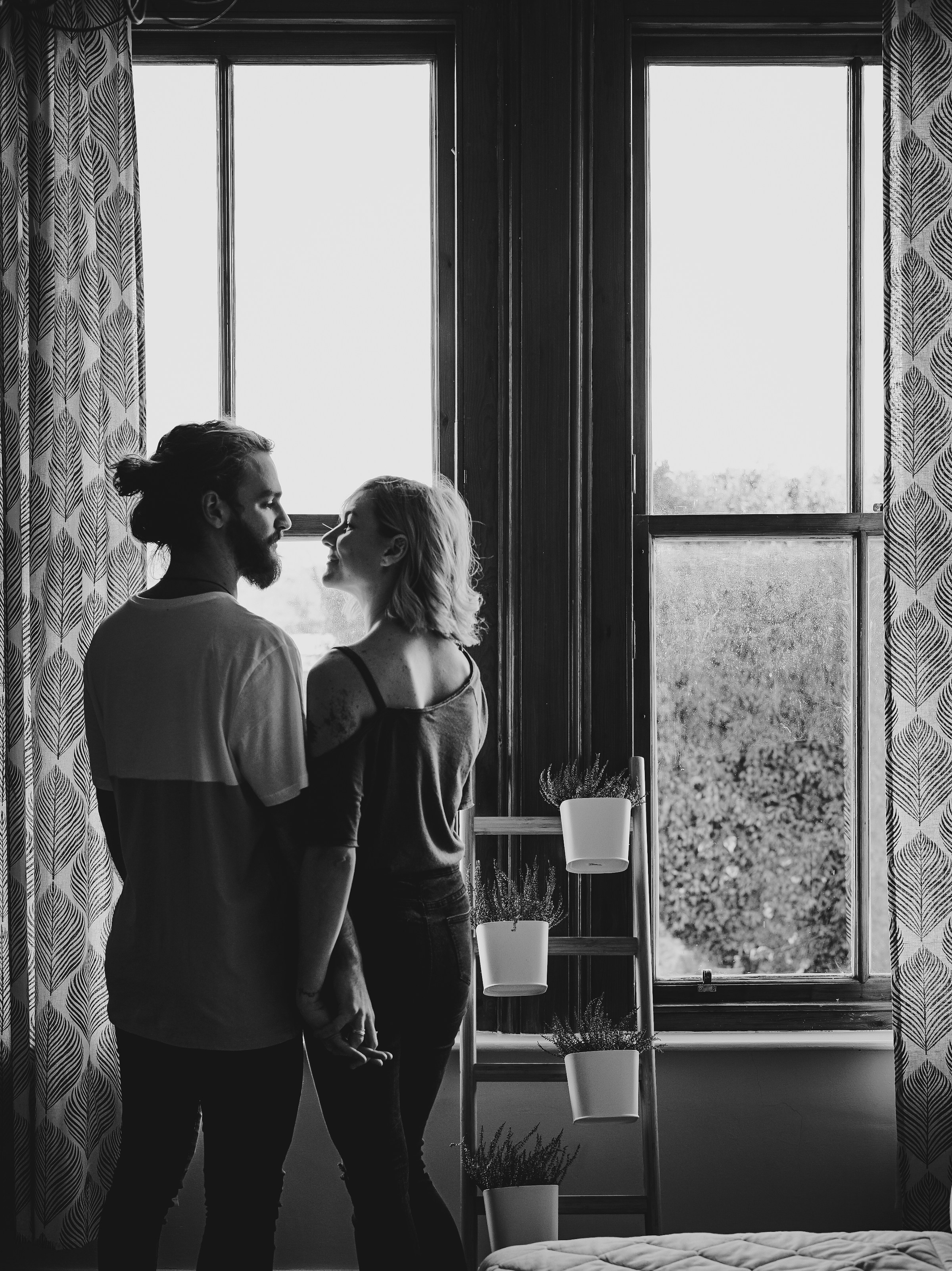 Una pareja sonriente junto a una ventana | Fuente: Unsplash