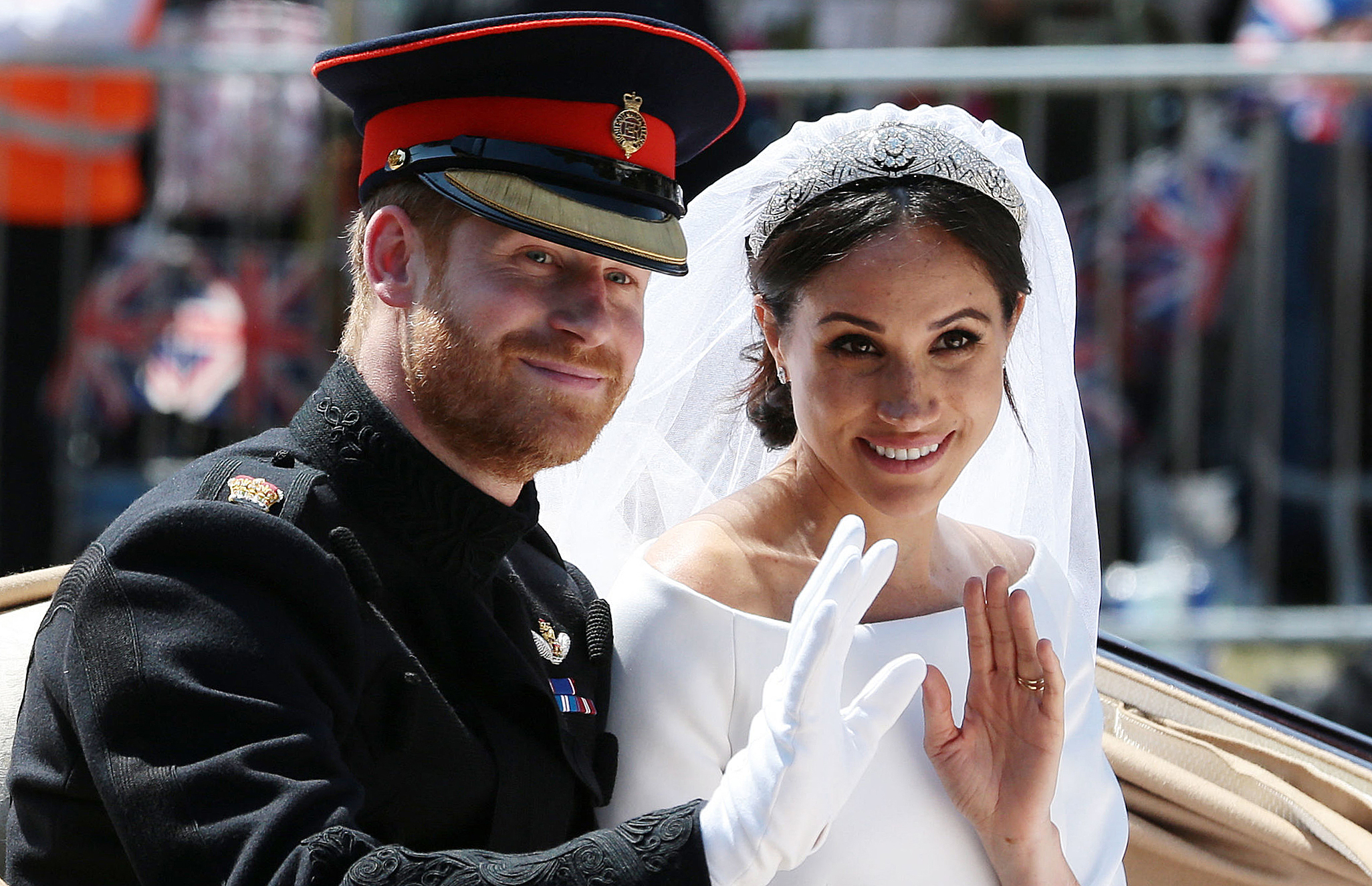 El príncipe Harry y Meghan Markle saludan desde el carruaje Ascot Landau durante su procesión en carruaje el día de su boda el 19 de mayo de 2018 en Windsor, Inglaterra. | Fuente: Getty Images