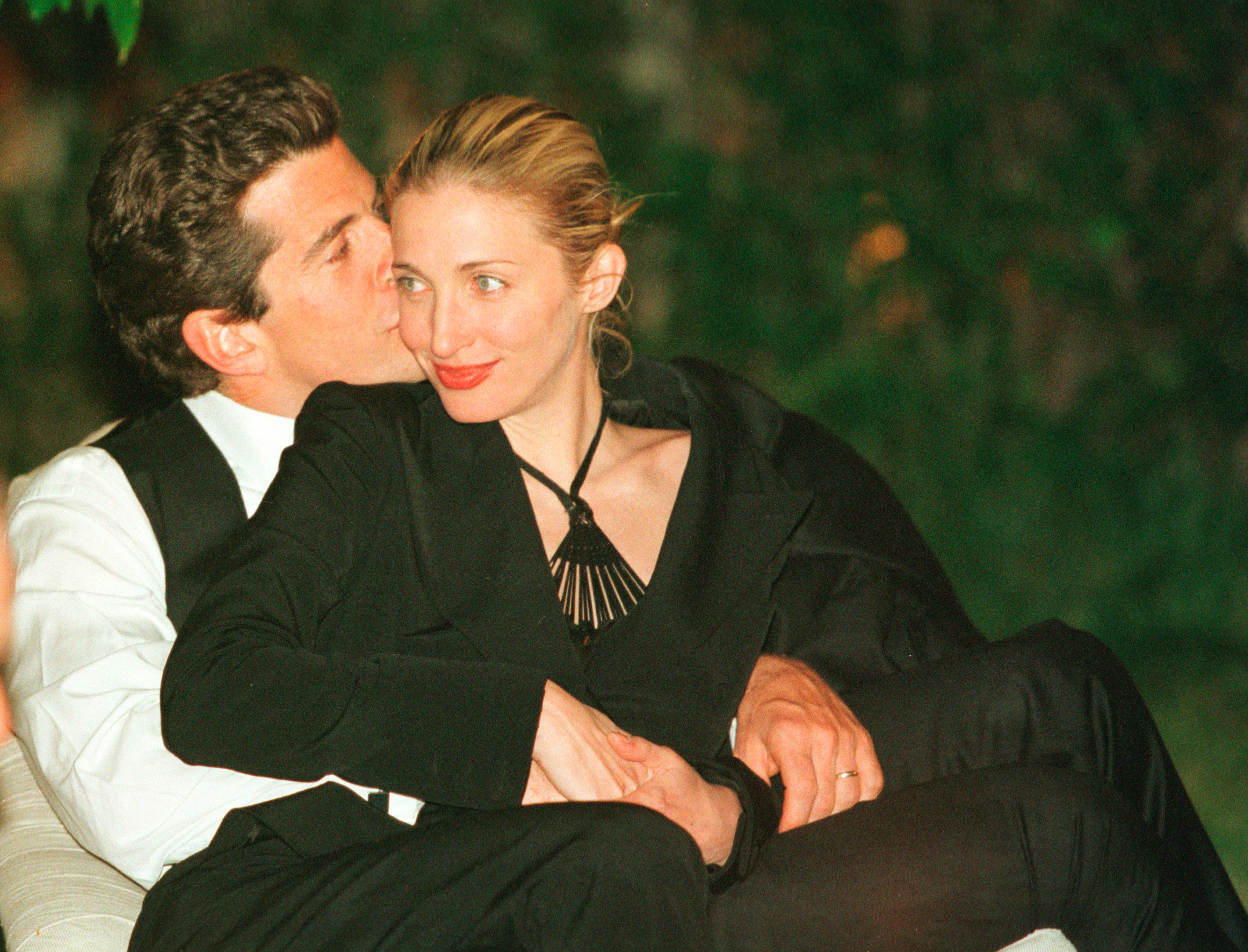 John F. Kennedy Jr. plantando un beso en la mejilla de Carolyn Bessette en la cena anual de Corresponsales de la Casa Blanca el 1 de mayo de 1999, en Washington, D.C. | Fuente: Getty Images