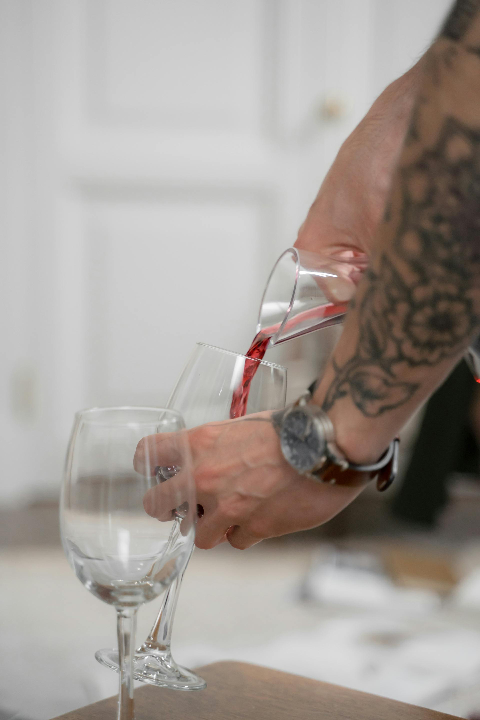 Un hombre sirviendo vino en un vaso | Fuente: Pexels