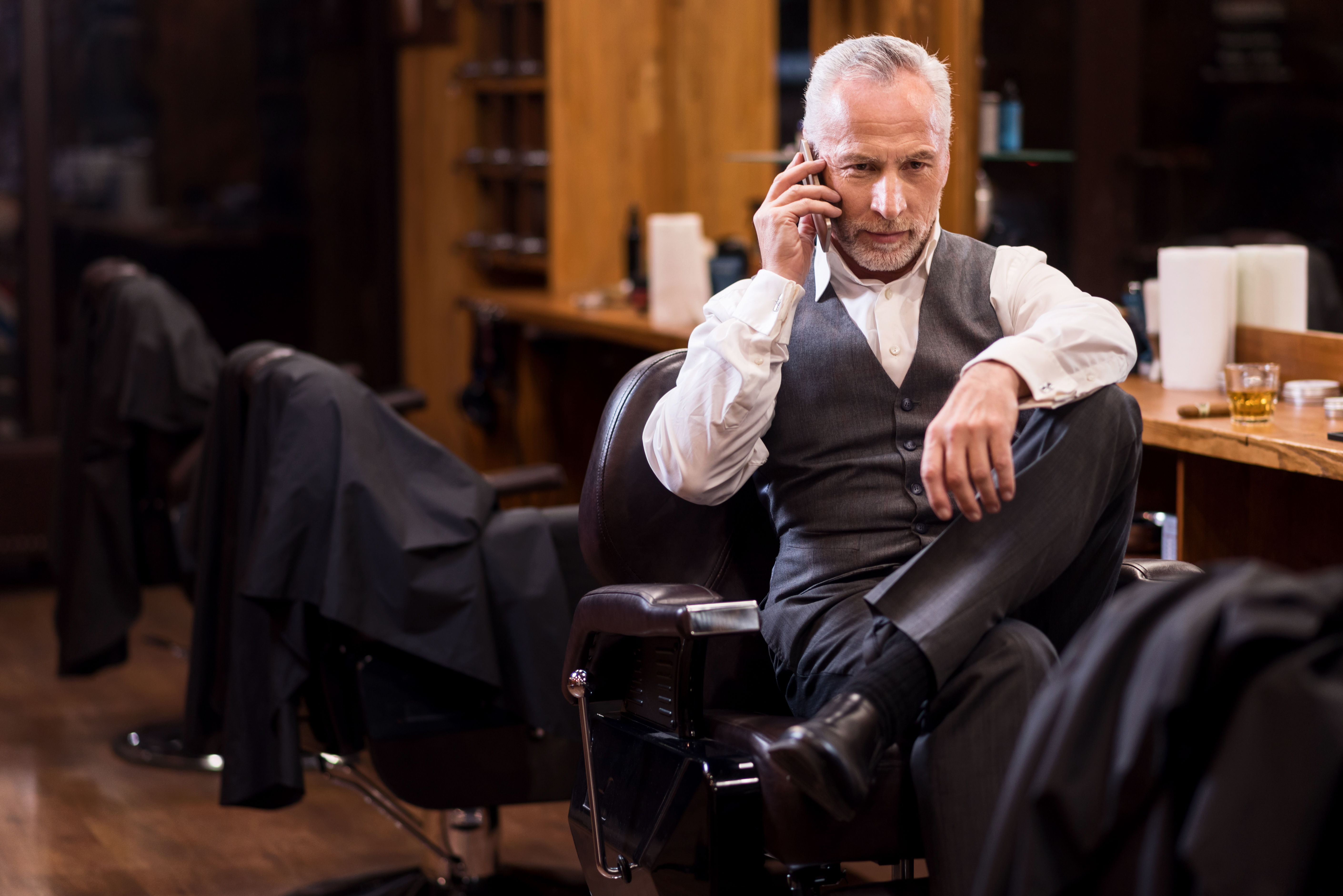 Hombre de negocios sentado hablando por el móvil. | Fuente: Shutterstock