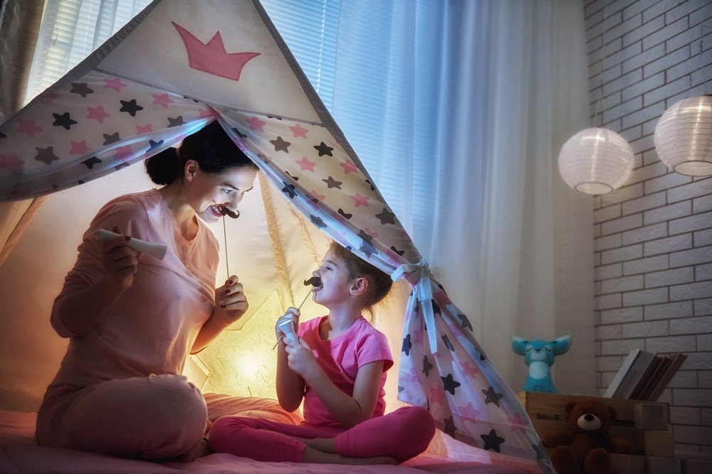 Madre y su hija juegan en la habitación antes de la hora de acostarse. Fuente: Shutterstock