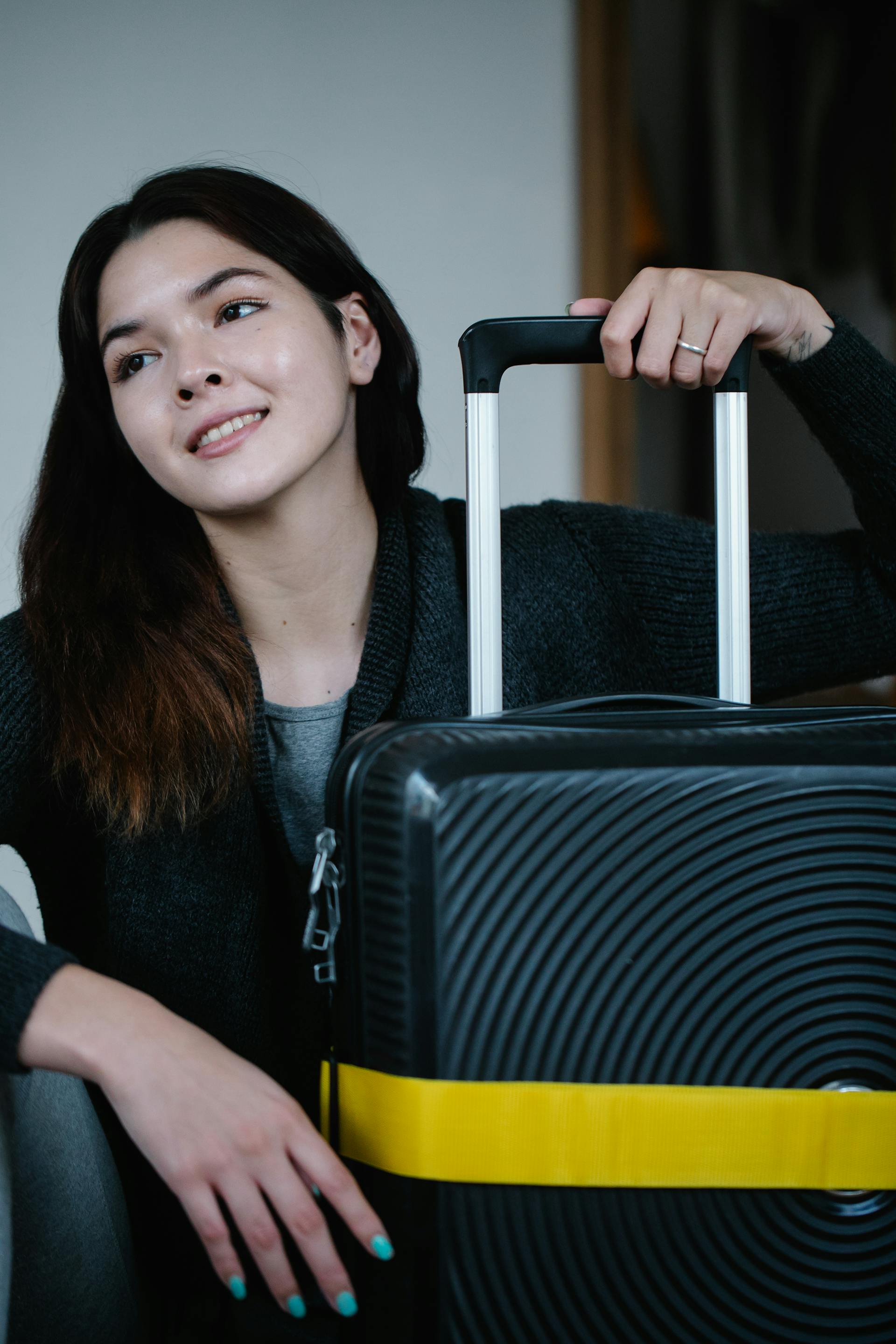 Una mujer feliz con un equipaje | Fuente: Pexels