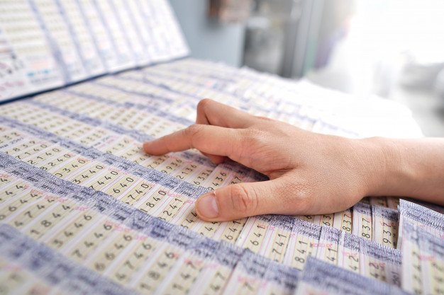 Persona eligiendo números de lotería. │Foto: Freepik