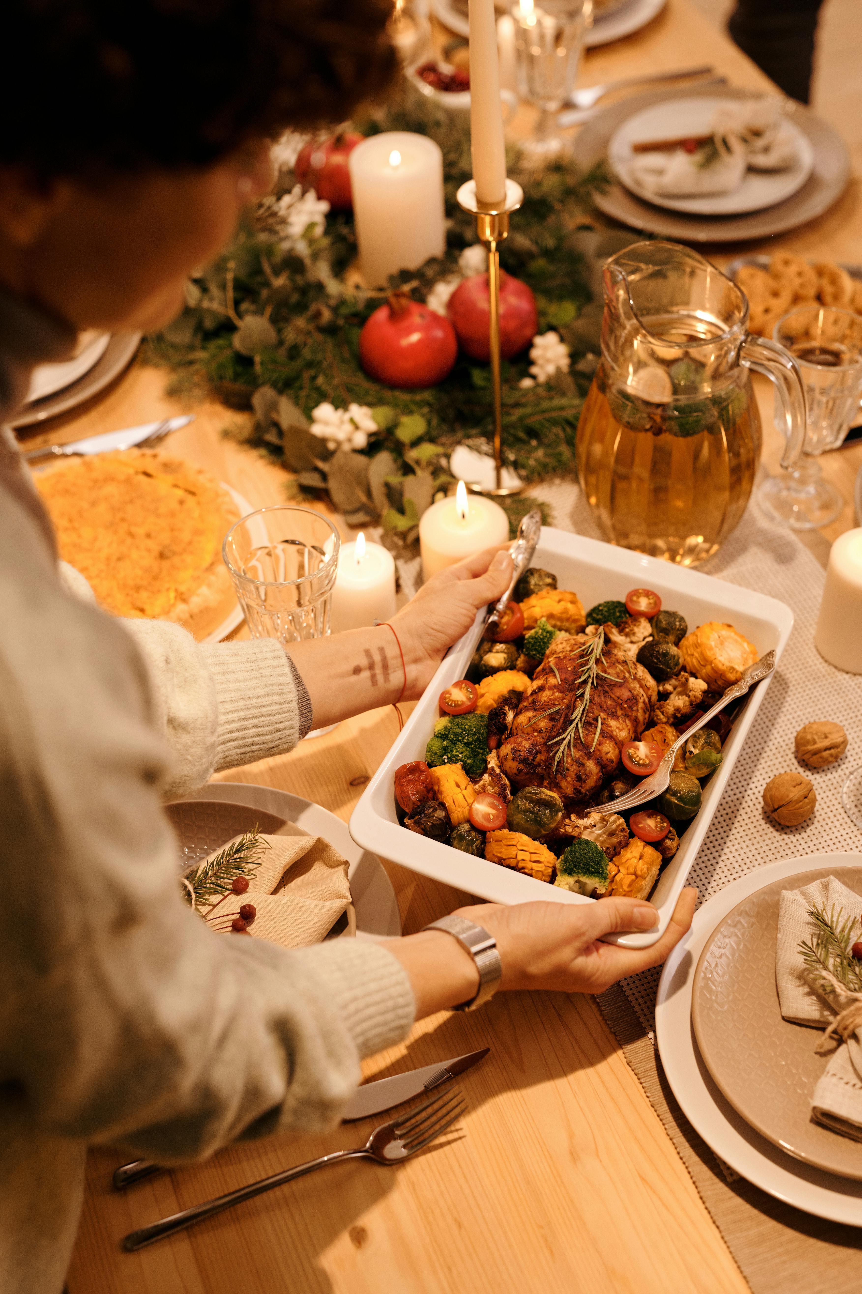 Una mujer colocando una bandeja de comida sobre la mesa | Fuente: Pexels