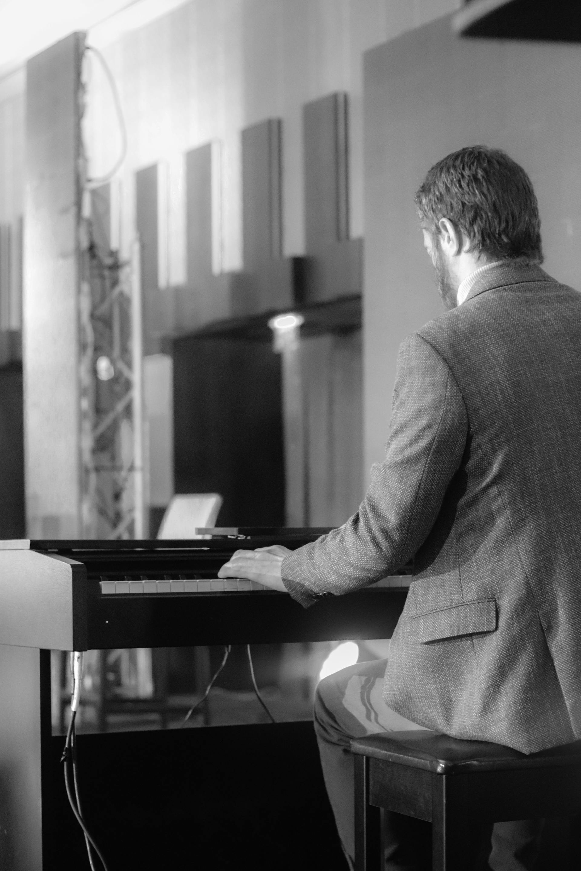 Foto en escala de grises de un hombre tocando un piano | Fuente: Pexels