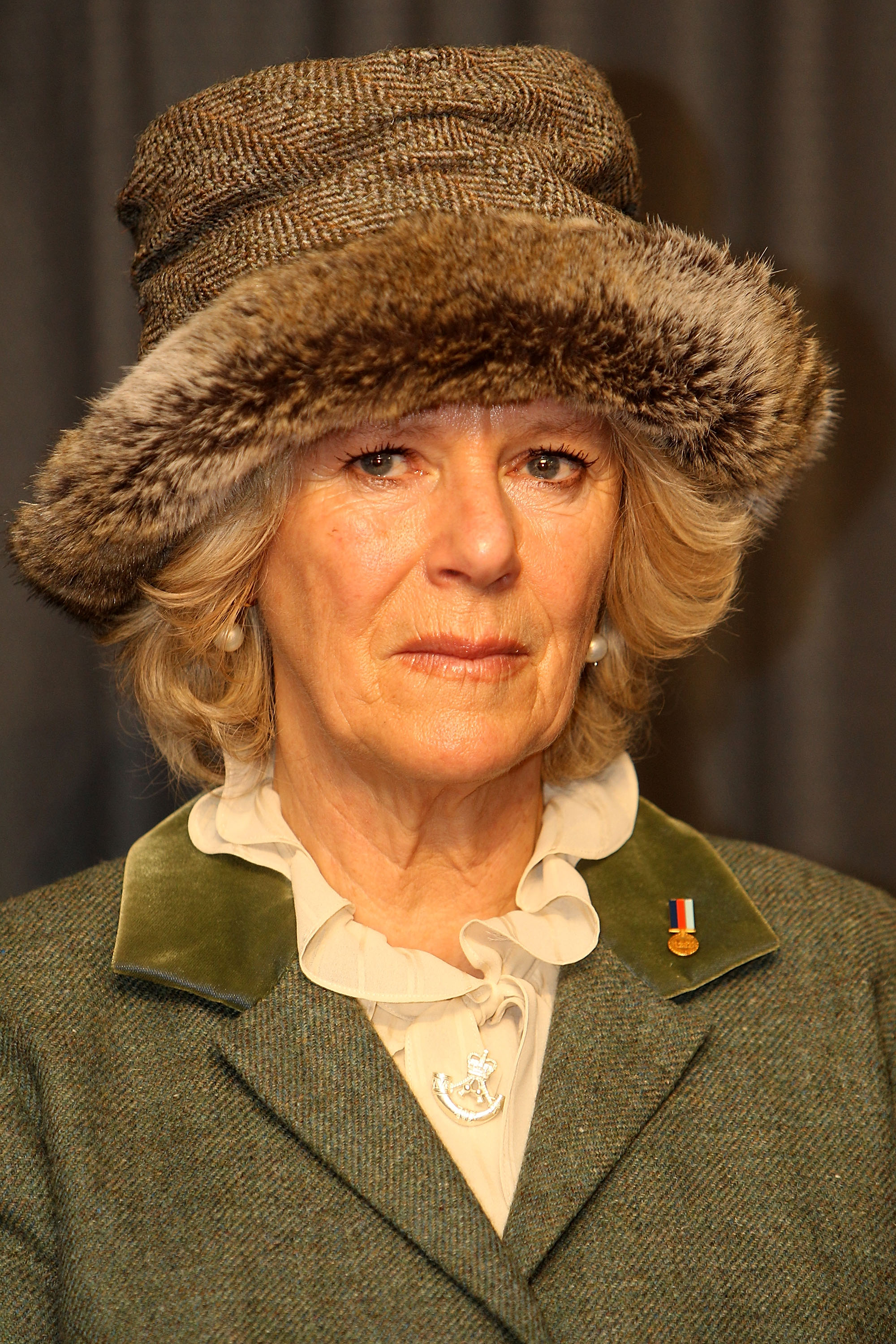 Camilla, duquesa de Cornualles lleva una insignia de Help for Heroes y también un motivo de The Rifles durante su visita a Wootton Bassett, Inglaterra, el 29 de enero de 2010 | Fuente: Getty Images