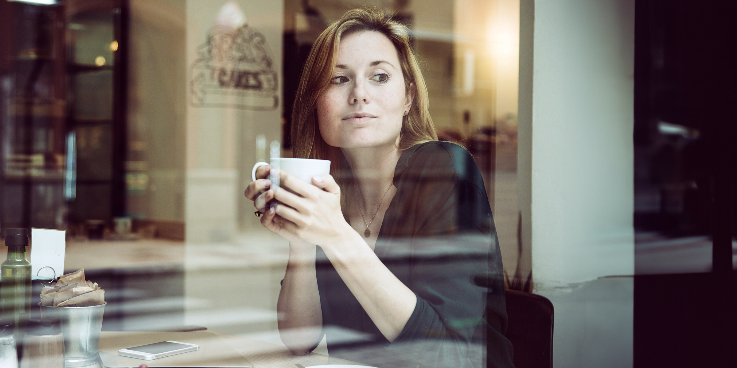 Una mujer sentada en una cafetería | Fuente: freepik.com/freepik