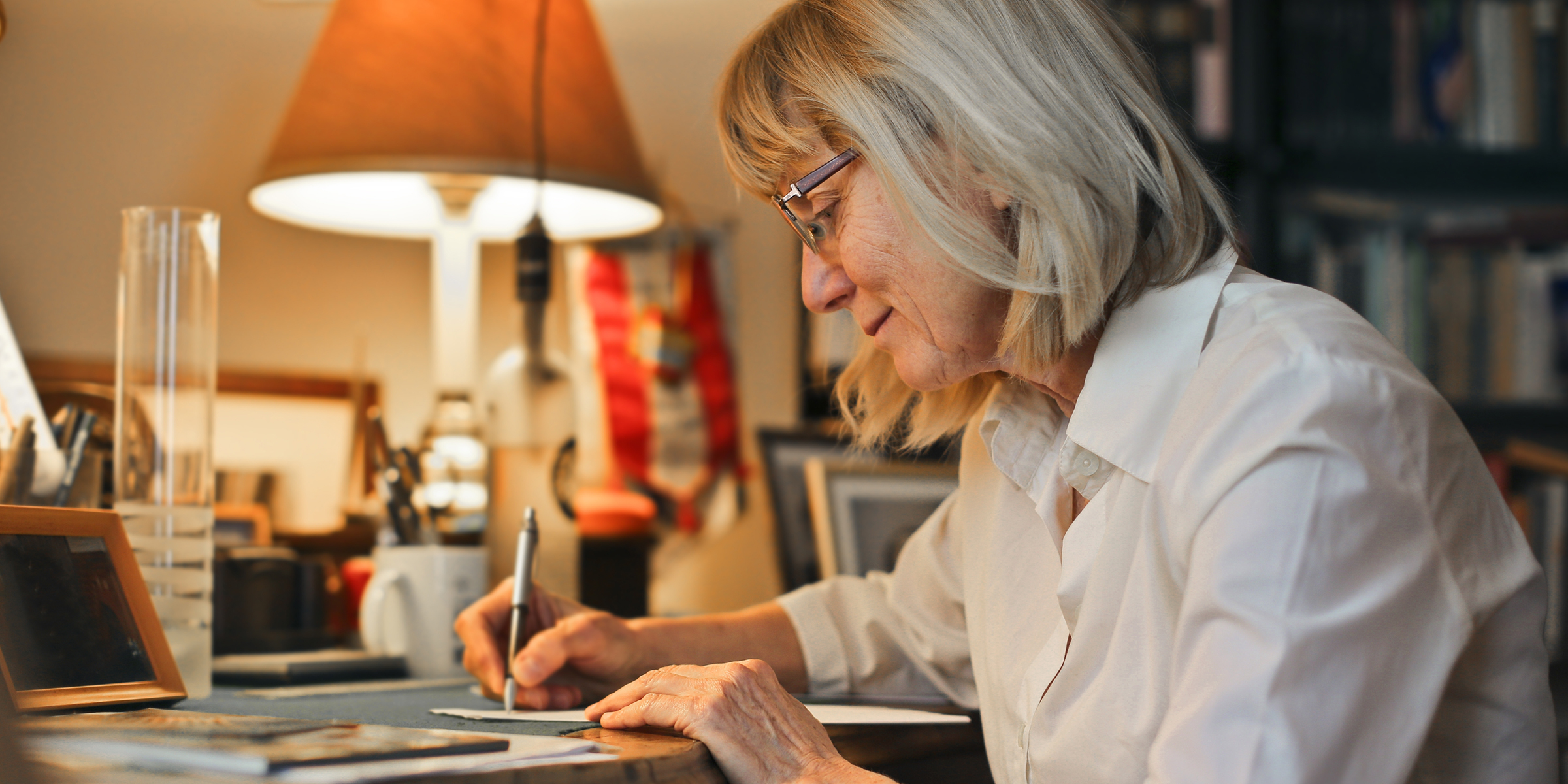 Una mujer mayor escribiendo una carta | Fuente: Shutterstock