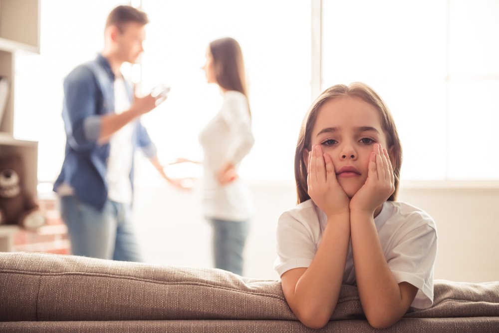 Niña triste está mirando mientras sus padres discuten en el fondo.  El |  Foto: Getty Images