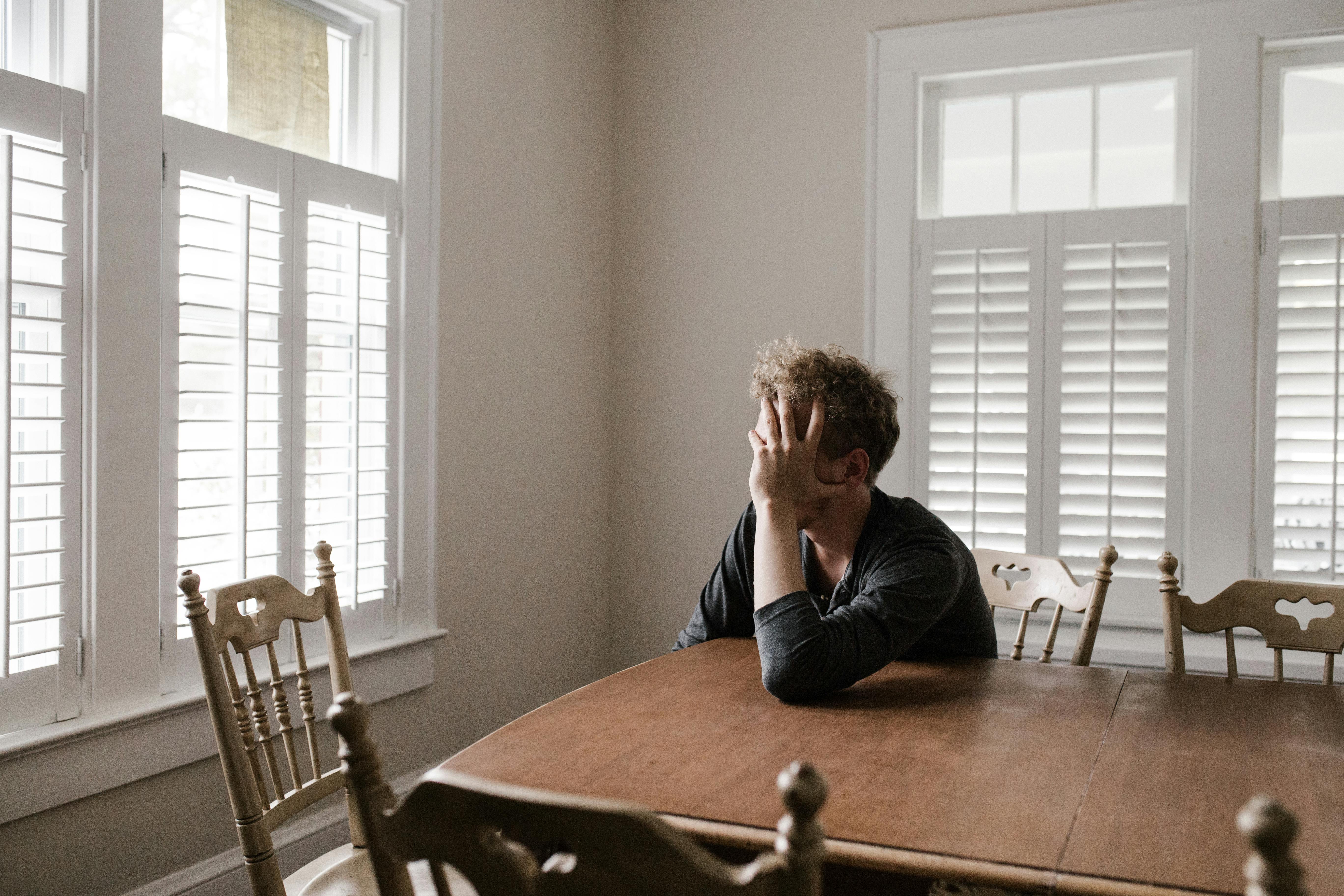 Un hombre triste en la mesa | Fuente: Pexels