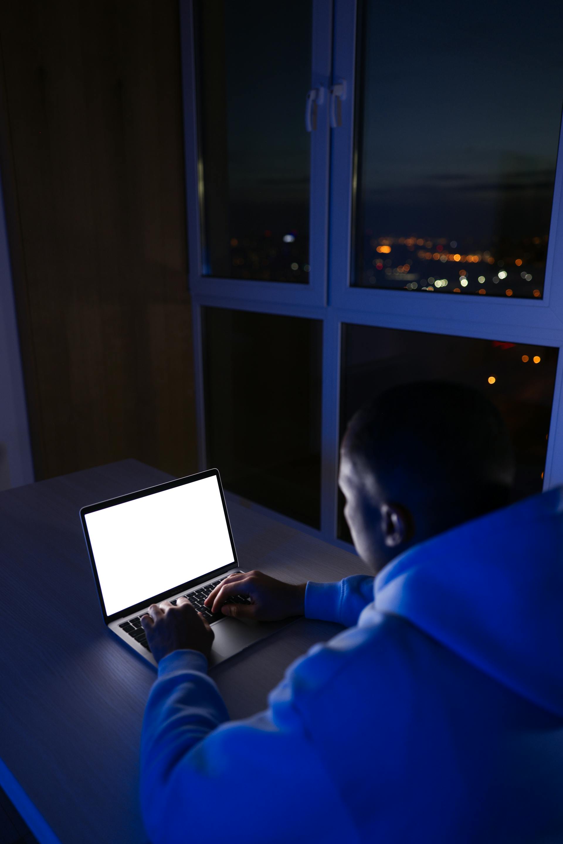 Un hombre trabajando de noche con un portátil | Fuente: Pexels