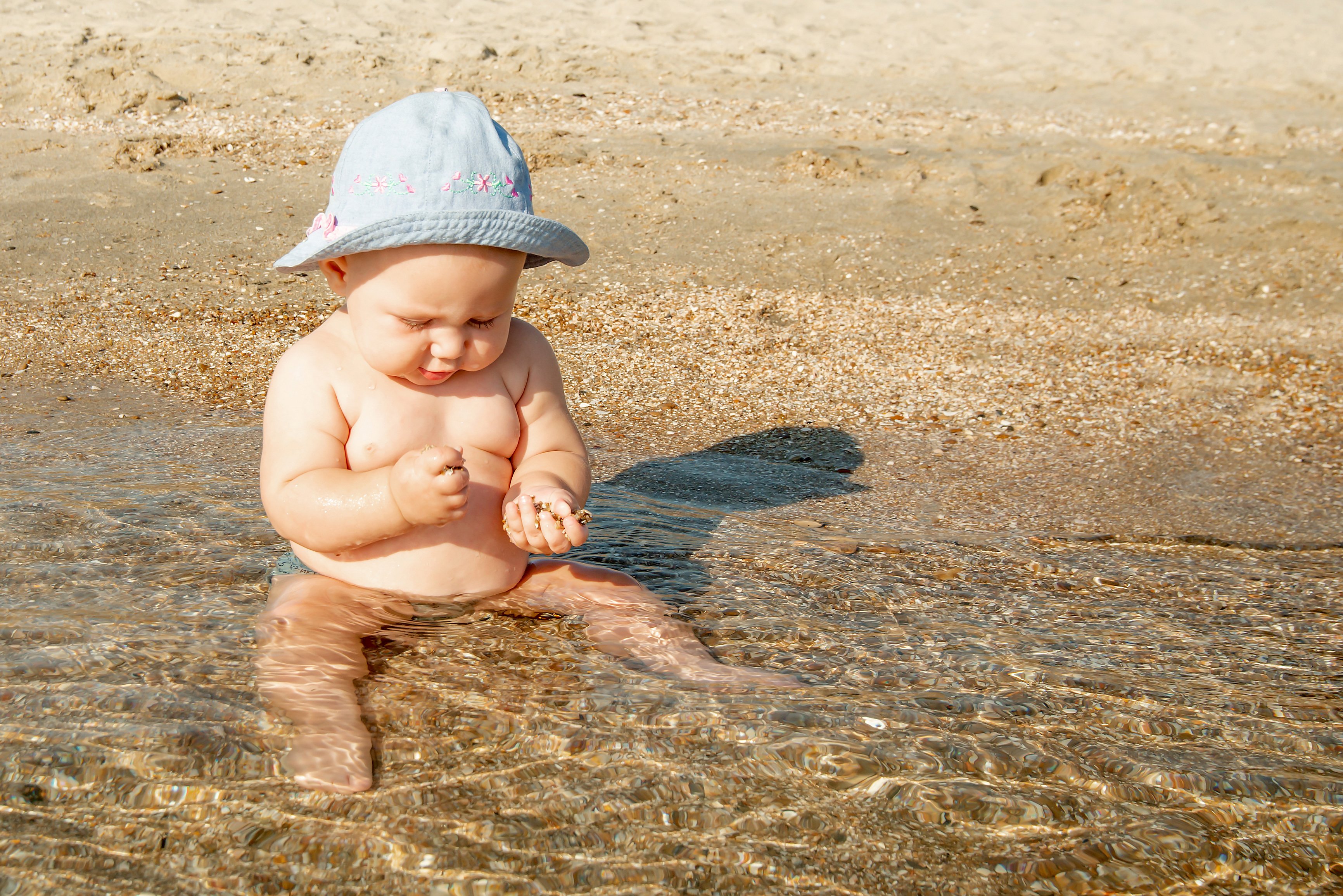 Bebé jugando con arena en la playa. | Foto: Shutterstock